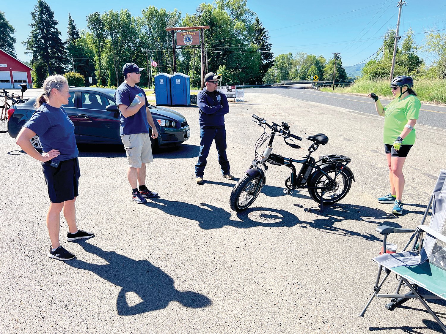 Volunteer firefighters with Lewis County Fire District 13 chat with a cyclist about their e-bike at the Baw Faw Grange rest stop at Ride the Willapa 2022.