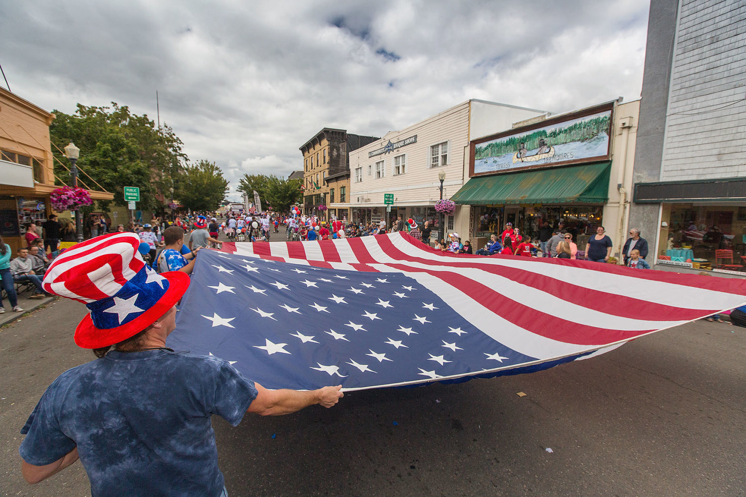 An American flag, large enough to take up most of the width of Tower Avenue in Centralia, is carried through the downtown streets during the Summerfest parade in 2017.