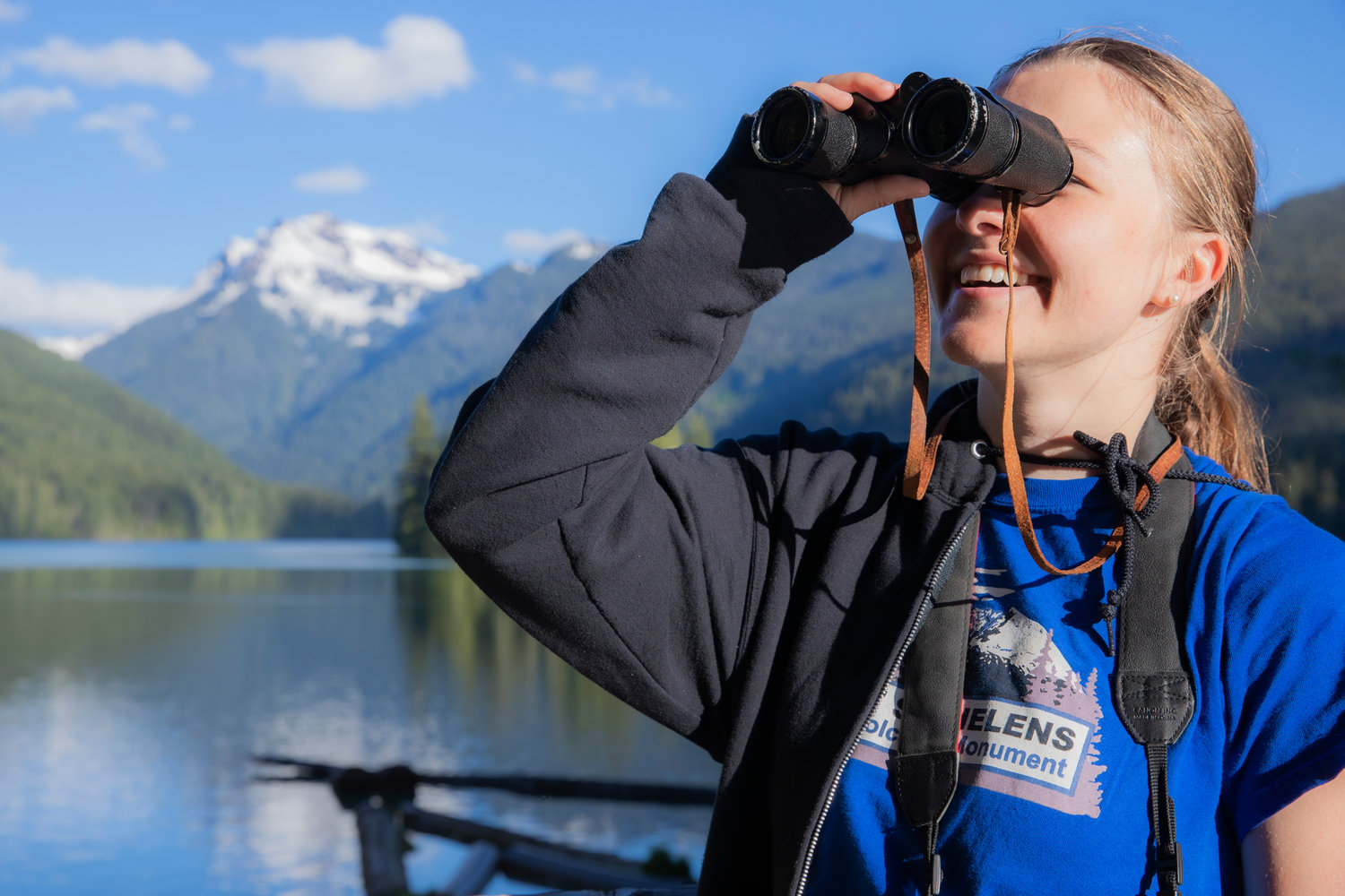 Reporter Isabel Vander Stoep smiles and looks on with binoculars Wednesday evening.