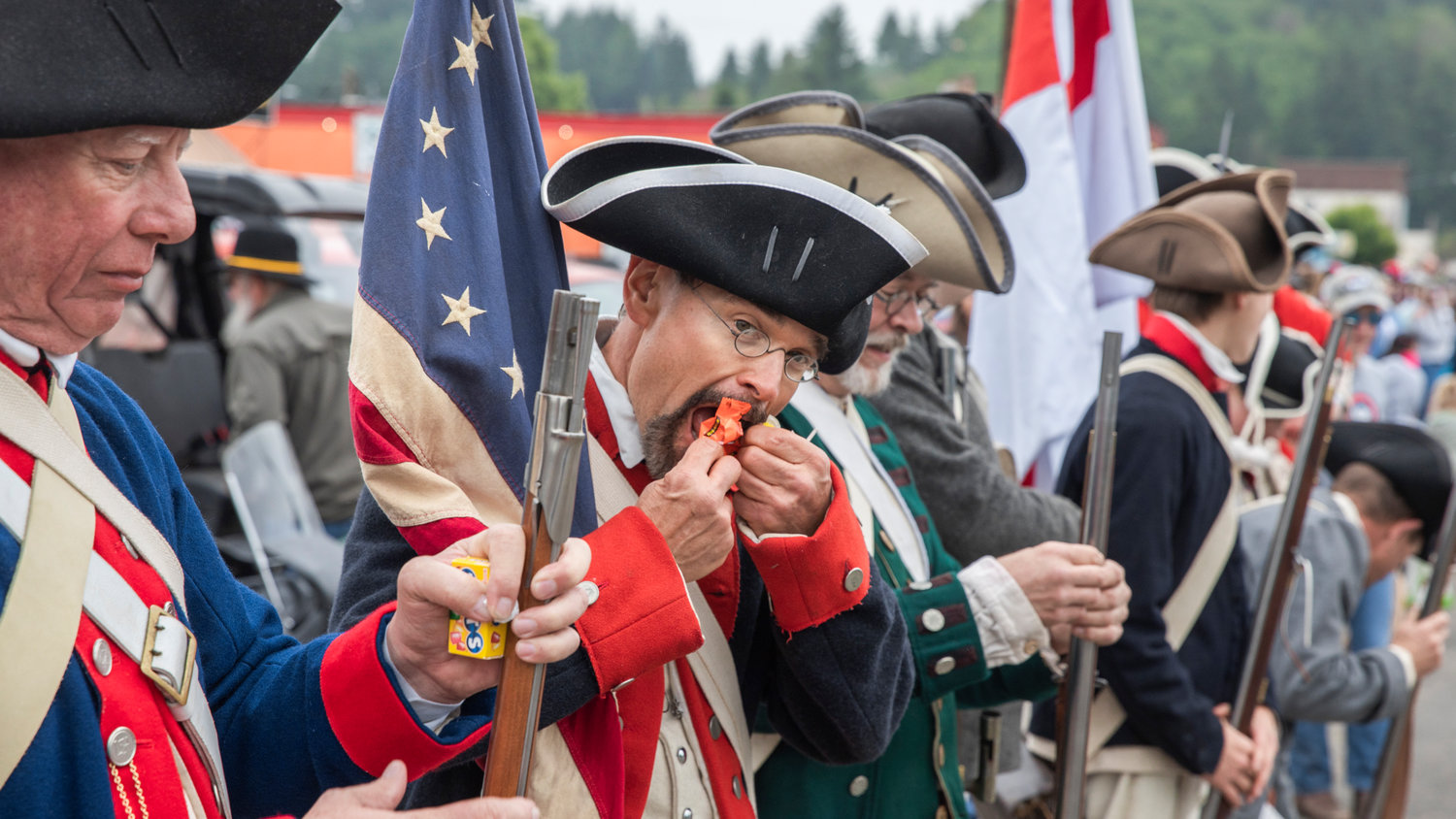 Attendees dressed in Revolutionary War garb unwrap candy during the Mossyrock Freedom Festival parade Saturday.