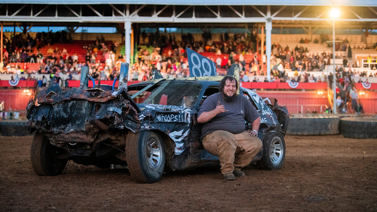 Josh Levine, 32, of Chehalis, poses with his car after winning the demolition derby main event at Centralia Summerfest at the Southwest Washington Fairgrounds on Sunday night.