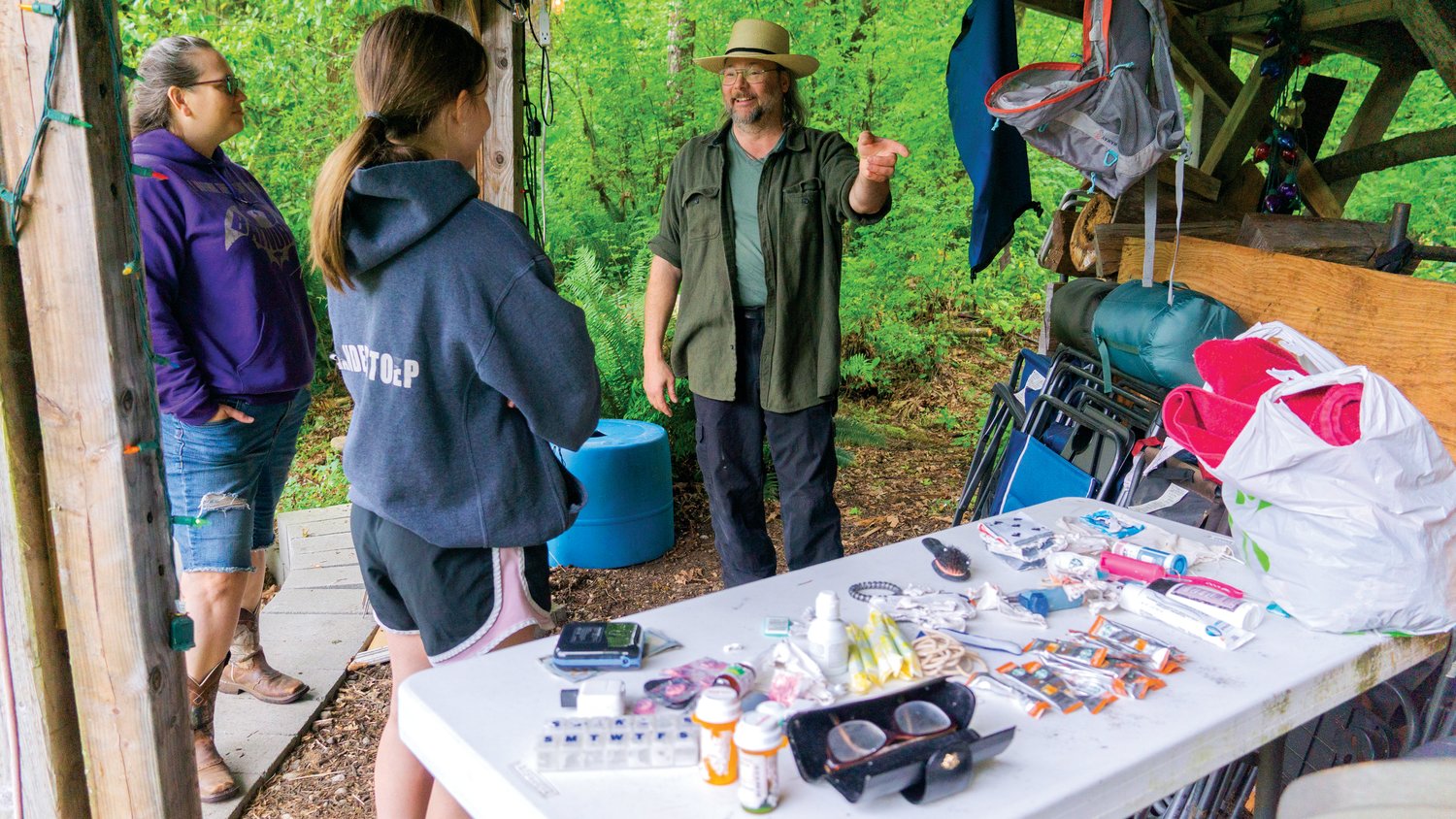 Chronicle reporter Isabel Vander Stoep speaks with Heather and Gryphon MacForrest after they returned the contents of a lost kayak. Some of the items recovered from the kayak on the Chehalis River are pictured on the table next to them.