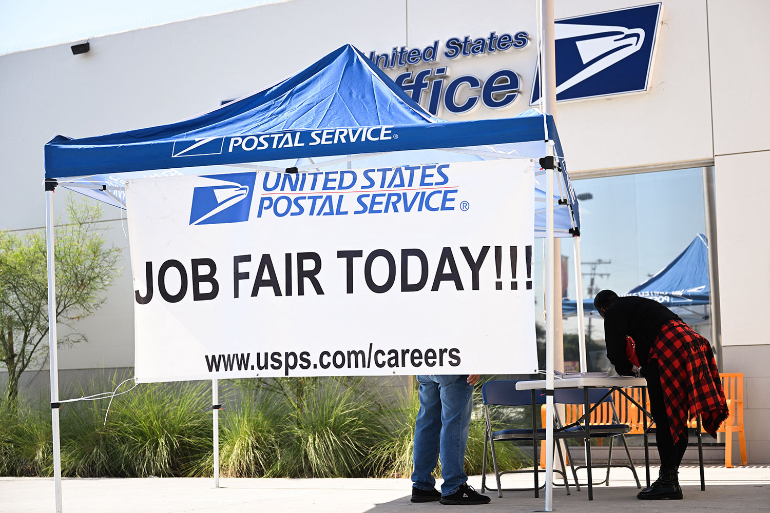 A person signs up for employment information outside during a job fair hiring new postal workers and mail carrier assistants at a United States Postal Service (USPS) post office on July 18, 2022, in Inglewood, California. (Patrick T. Fallon/AFP via Getty Images/TNS)