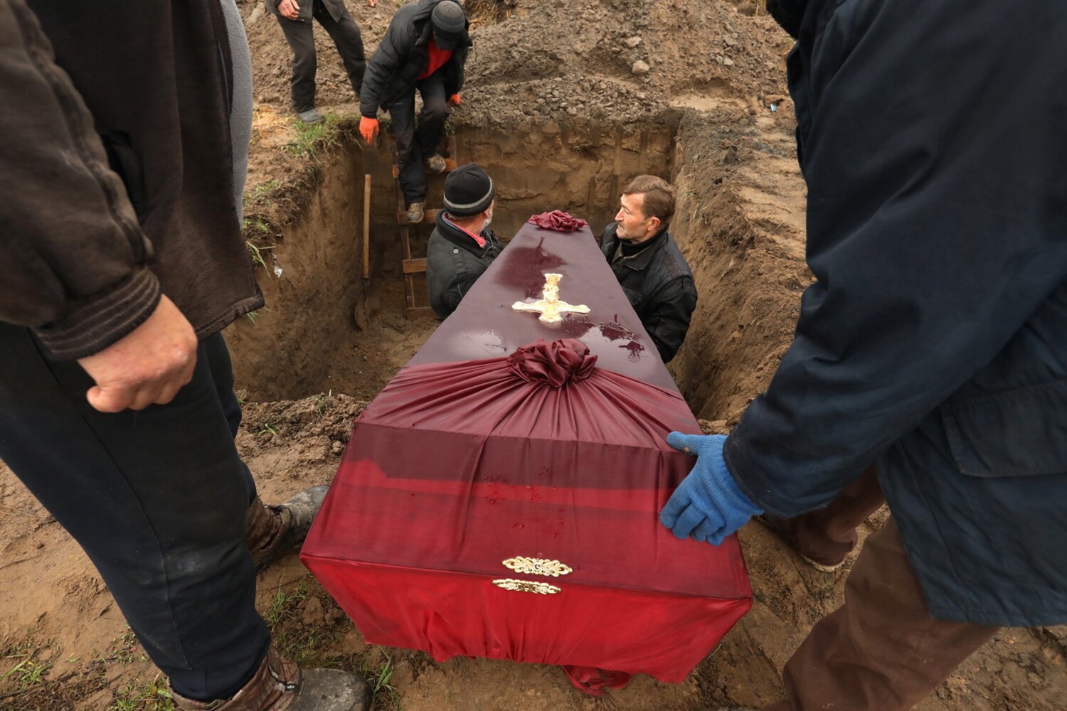 Three members of the Ostrovskii family including Viktorya, age 51, Anatoli, age 75, and Vyacheslav, age 32, were buried together in a single grave at the Bucha cemetery on April 22, 2022. The three were shot and killed by Russians on March 7, as they tried to flee Bucha, Ukraine in their car according to a family friend who was there to oversee their burial. Over 700 bodies have been brought to morgues in the area, which are being investigated for war crimes. (Carolyn Cole/Los Angeles Times/TNS)