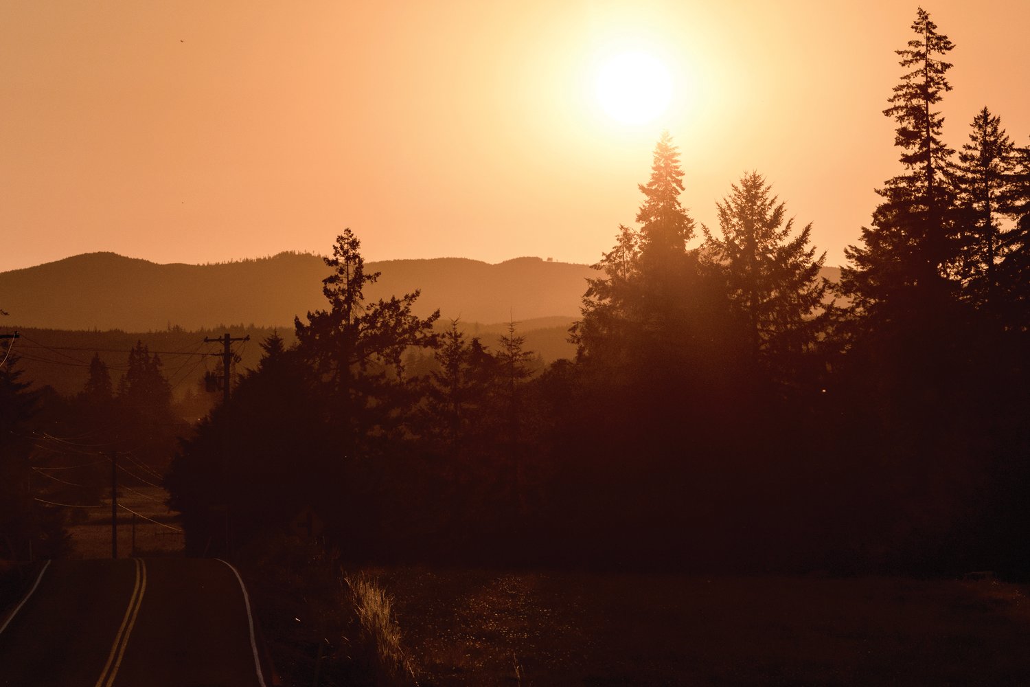 The sun sets over the Willapa Hills as seen from Twin Oaks Road Wednesday evening.