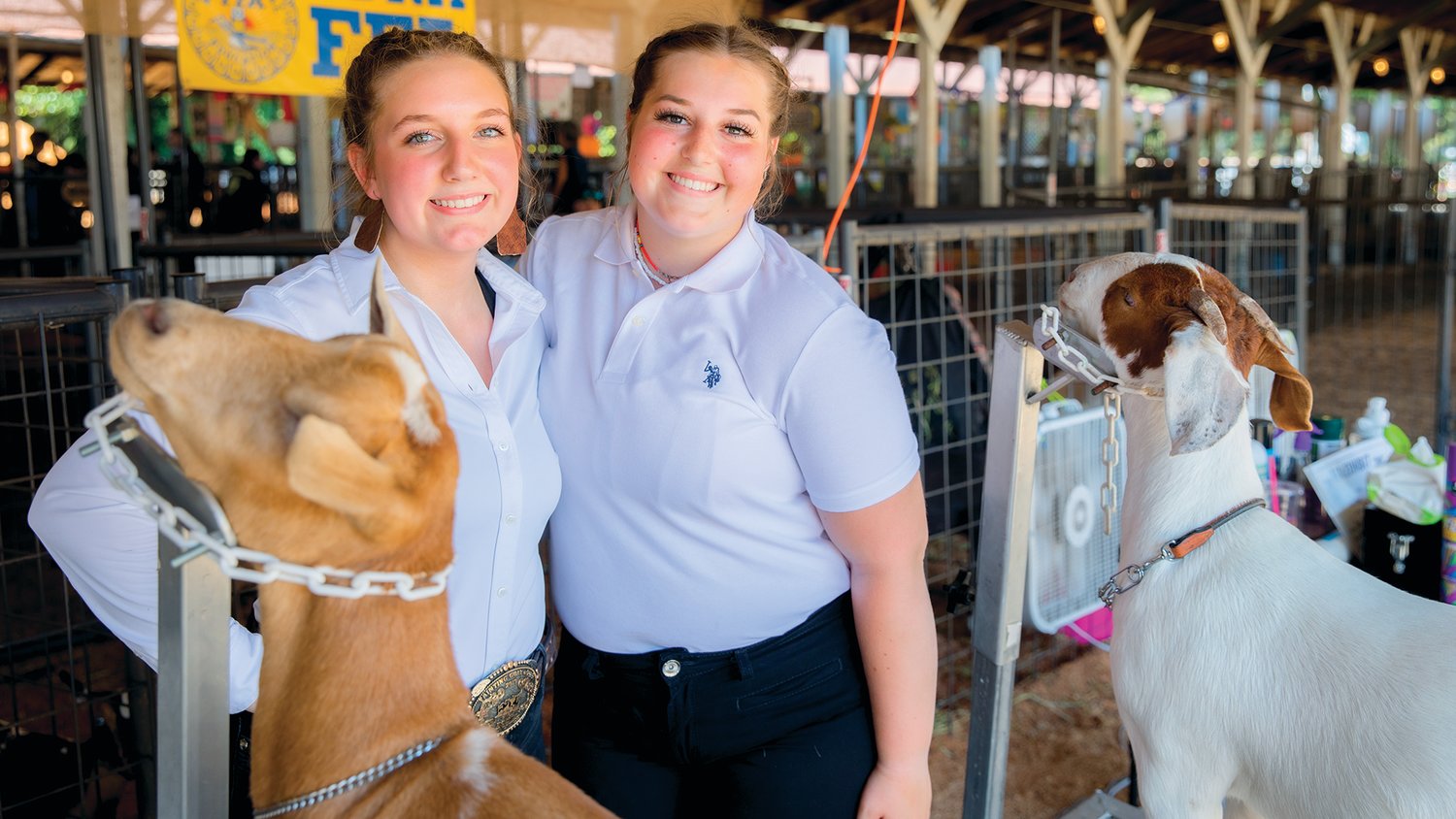 Callie Thomas and Clara Price, of Chehalis, smile for a photo with goats Lani and Charlie at the Thurston County Fair on Thursday.
