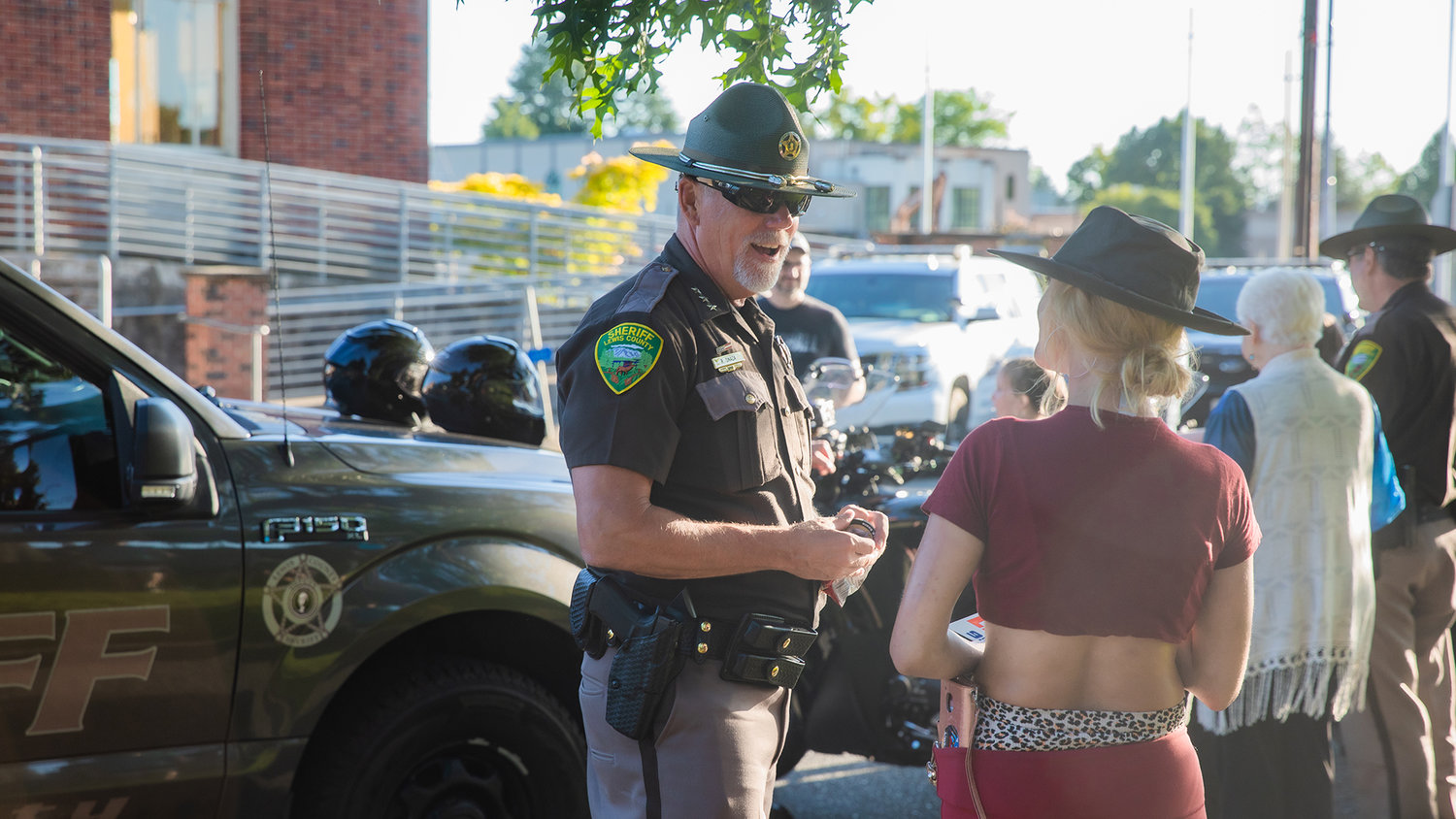 Rob Snaza, with the Lewis County Sheriff’s Office, smiles while greeting attendees of a National Night Out event hosted Tuesday night at George Washington Park in Centralia.