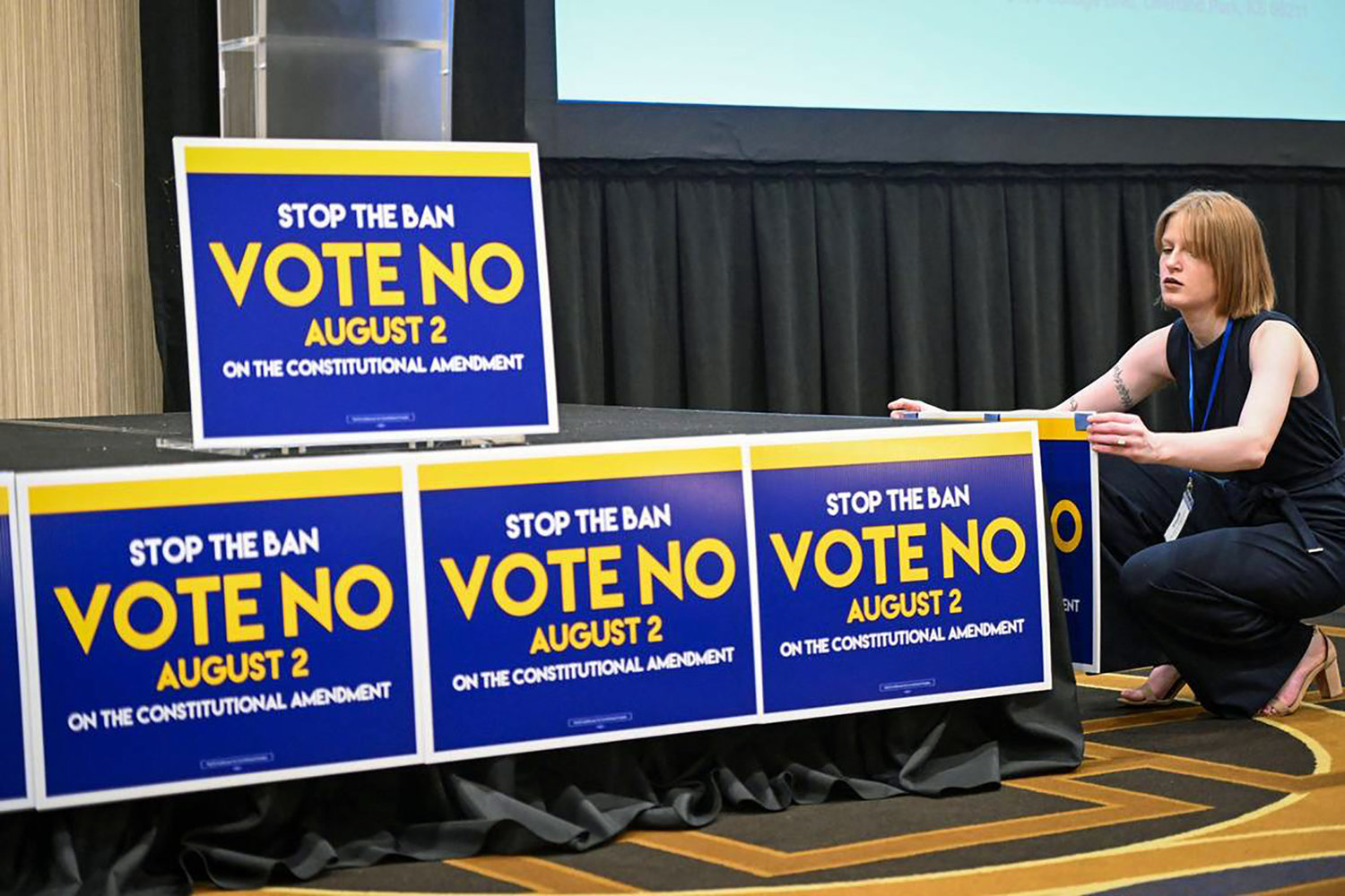 Jae Gray, a field organizer with Kansans for Constitutional Freedom, posted signs at the watch party for election results Tuesday, Aug. 2, 2022, at the Overland Park Convention Center. The group was supporting a no vote on the constitutional amendment on the ballot. (Tammy Ljungblad/The Kansas City Star/TNS)