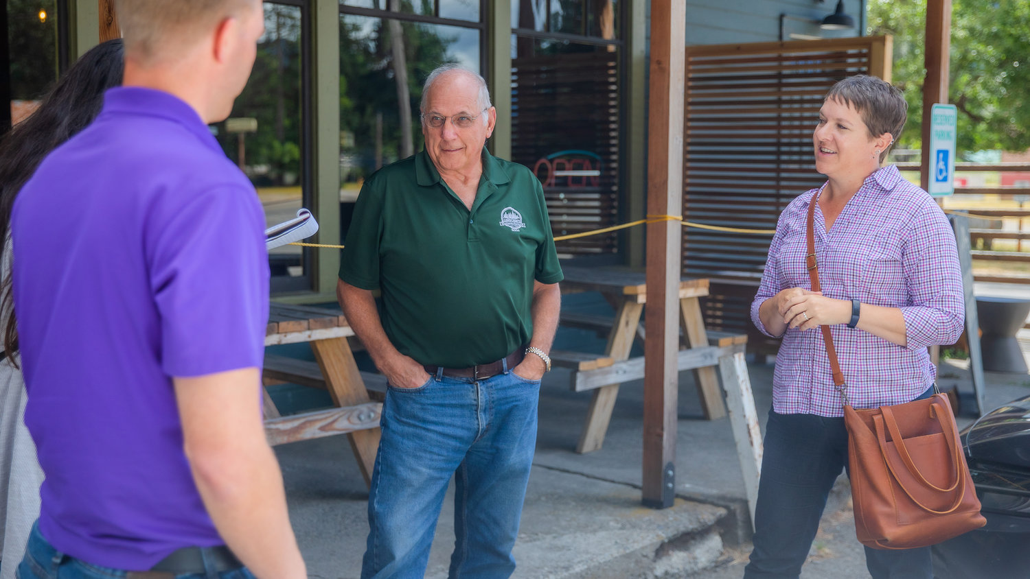 Commissioner Lee Grose and Lewis County Senior Long Range Planner Mindy Brooks talk with representatives from U.S. Congresswoman Jamie Herrera Beutler’s and Senator Maria Cantwell’s offices Thursday outside the Packwood Brewing Co.