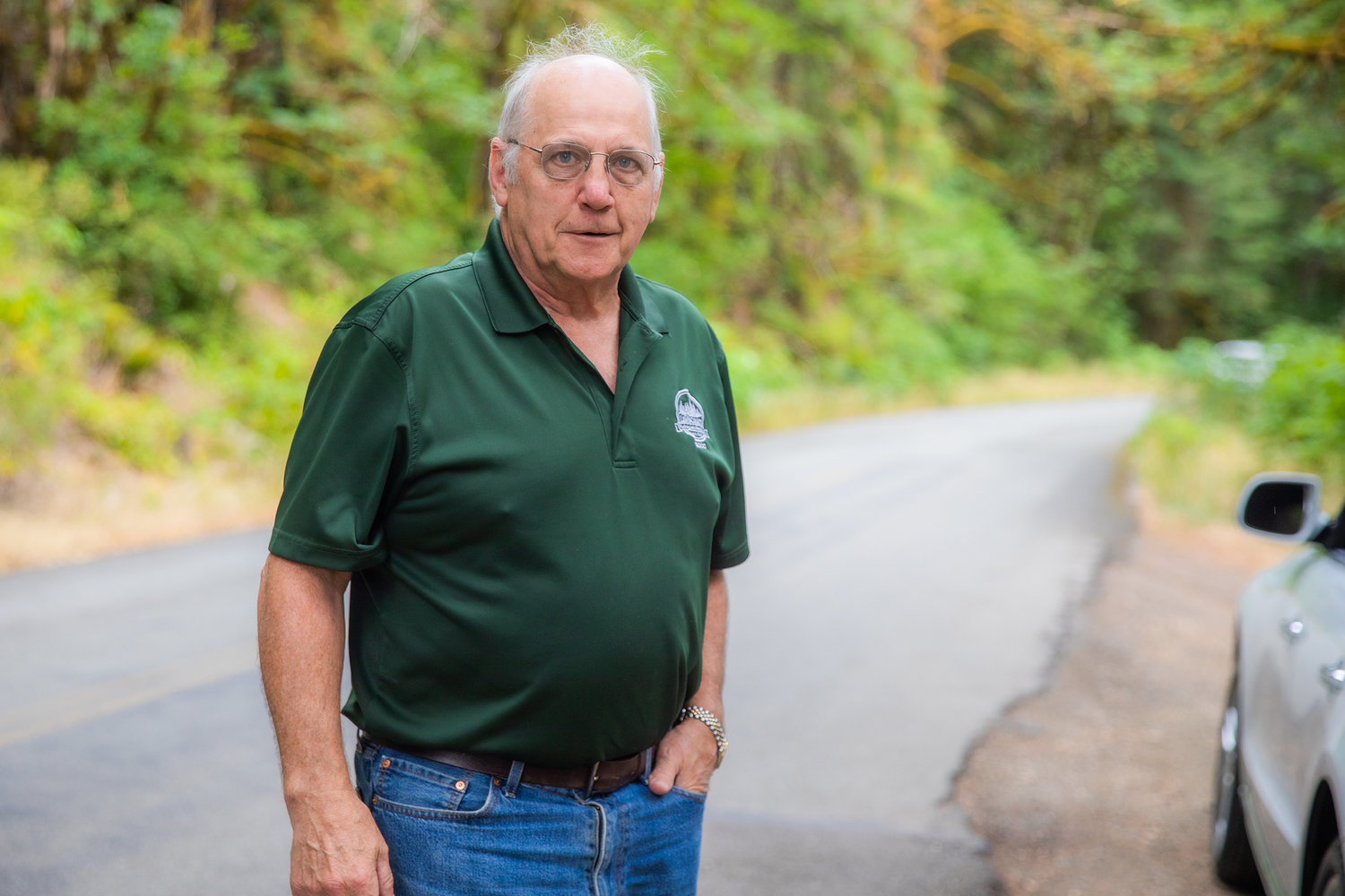 Commissioner Lee Grose talks about flat tires caused by potholes Thursday along National Forest Road 52 near Packwood.