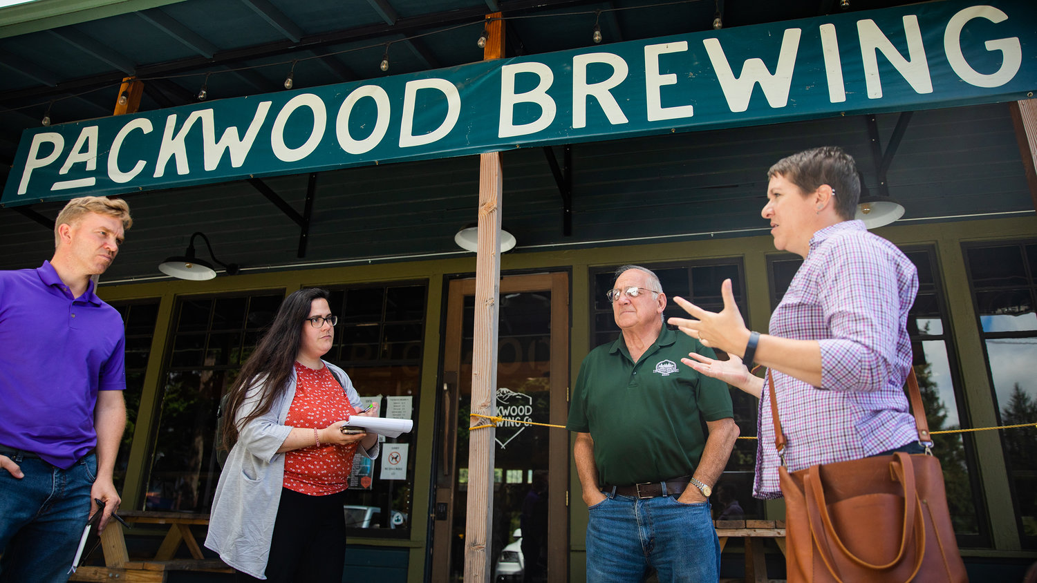 Lewis County Senior Long Range Planner Mindy Brooks, far right, and Commissioner Lee Grose talk with representatives from U.S. Congresswoman Jamie Herrera Beutler’s and Senator Maria Cantwell’s offices Thursday outside the Packwood Brewing Co.