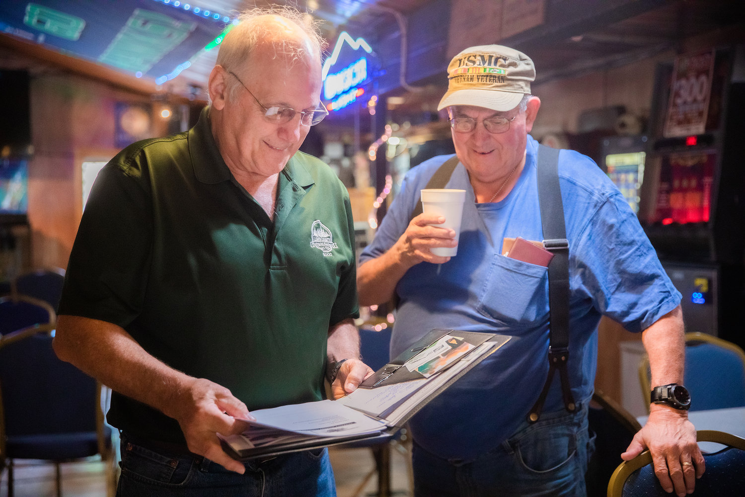 Commissioner Lee Grose laughs and talks with George Schaefer, a U.S. Marine Corps veteran, Thursday in Randle at the Tall Timber Restaurant.