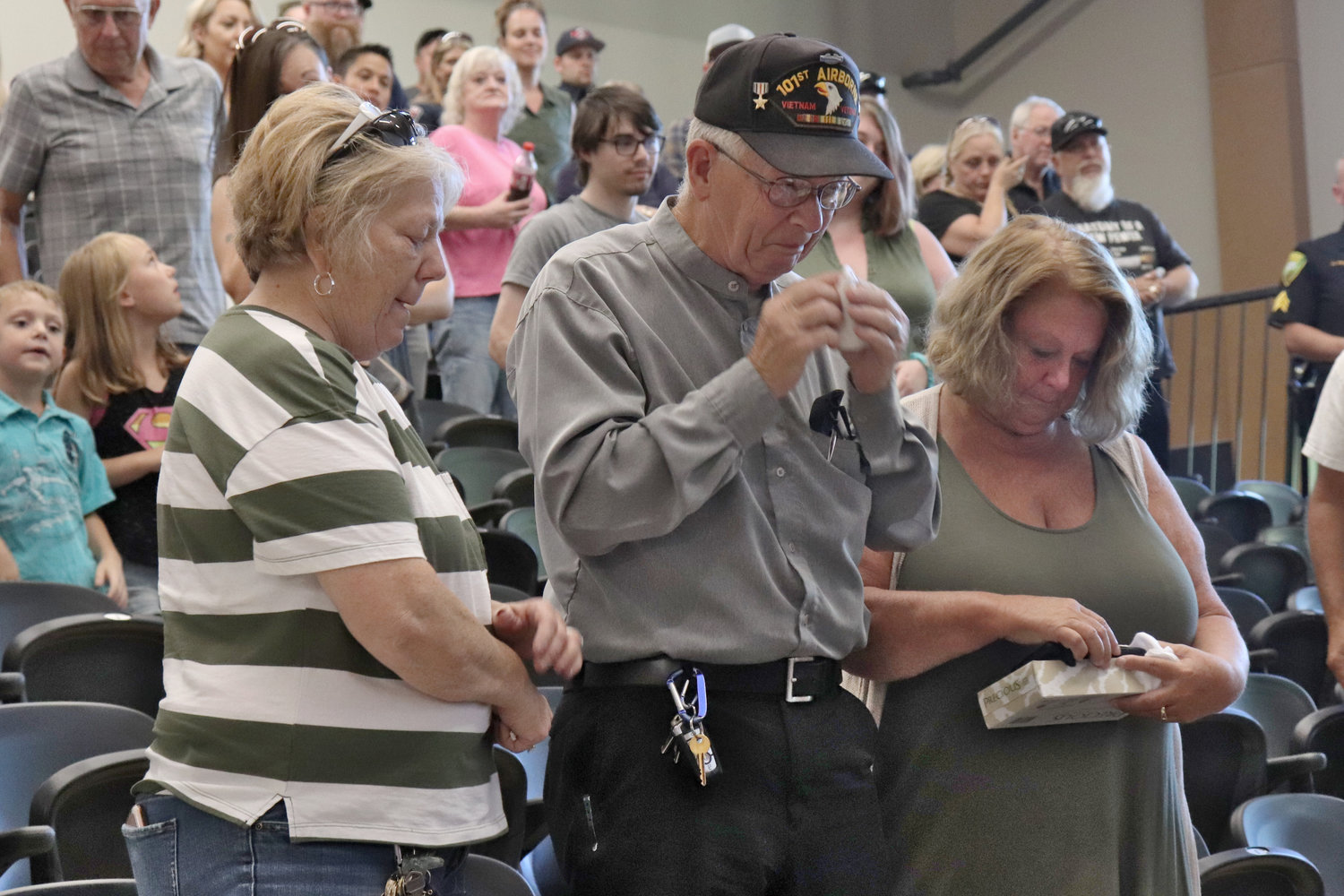 Retired Toledo Reserve Sergeant Randy Pennington, center, and members of his family get teary after Pennington receives a standing ovation from Toledo community during his retirement party at Toledo High School on Thursday.