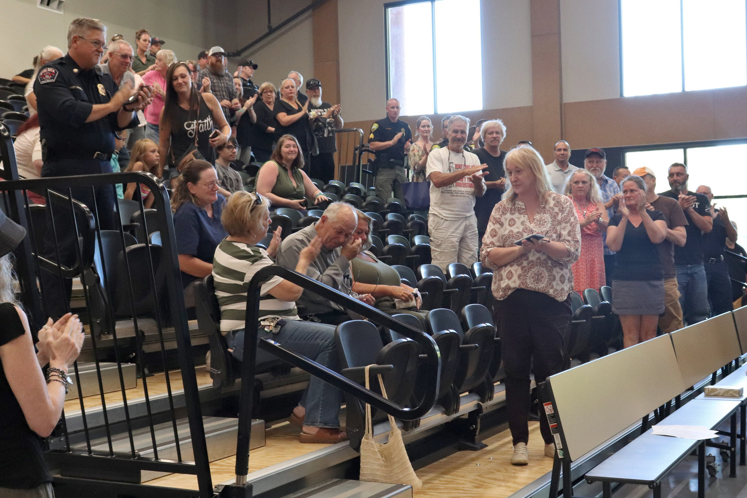 Retired Reserve Sergeant Randy Pennington receives a standing ovation from members of the Toledo community during his retirement party at Toledo High School on Thursday.