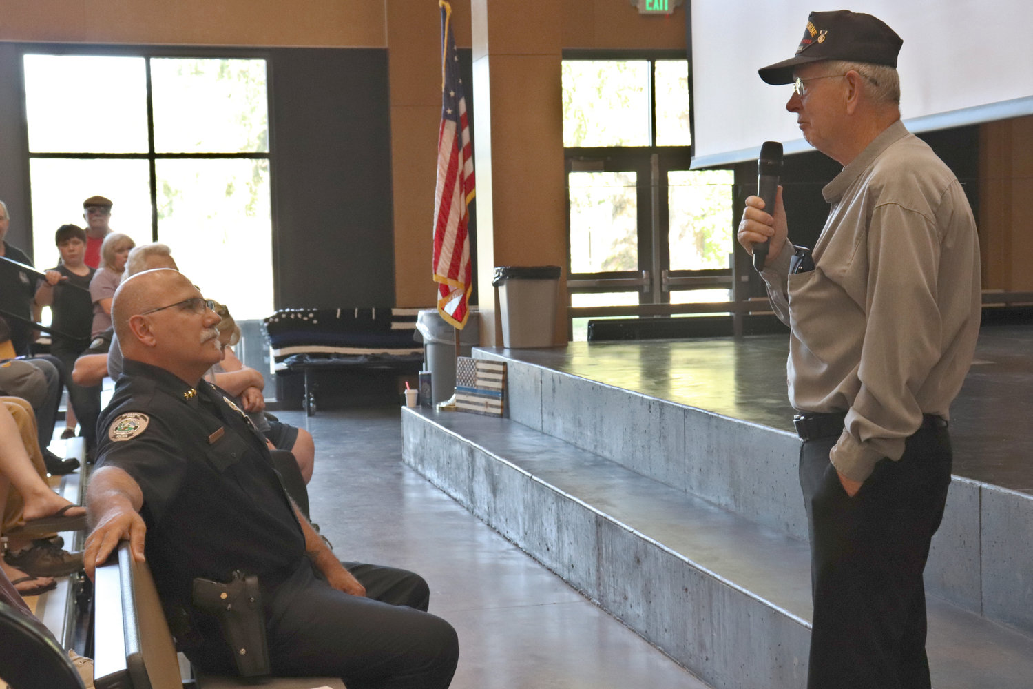 Retired Reserve Sergeant Randy Pennington, right, addresses former Toledo Police Chief John Brockmueller during Pennington’s retirement party at Toledo High School on Thursday.