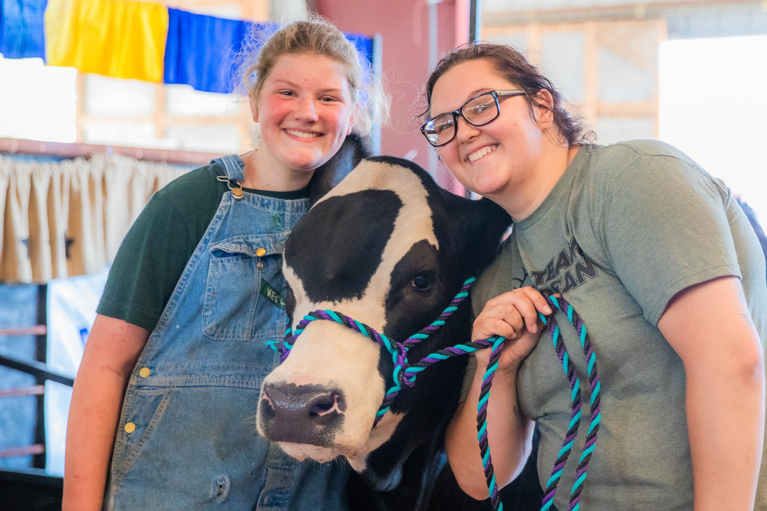 Zeanna Zavodsky, 13, and Tearra Shipp, 19, smile for a photo with Froggy, a Simmental, Monday afternoon at the Southwest Washington Fairgrounds in Centralia.