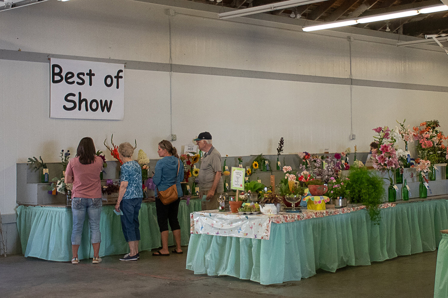 Locals examine the best-of-show flowers at the exhibit where local growers compete to see who has the best green thumb. Photo by Owen Sexton.