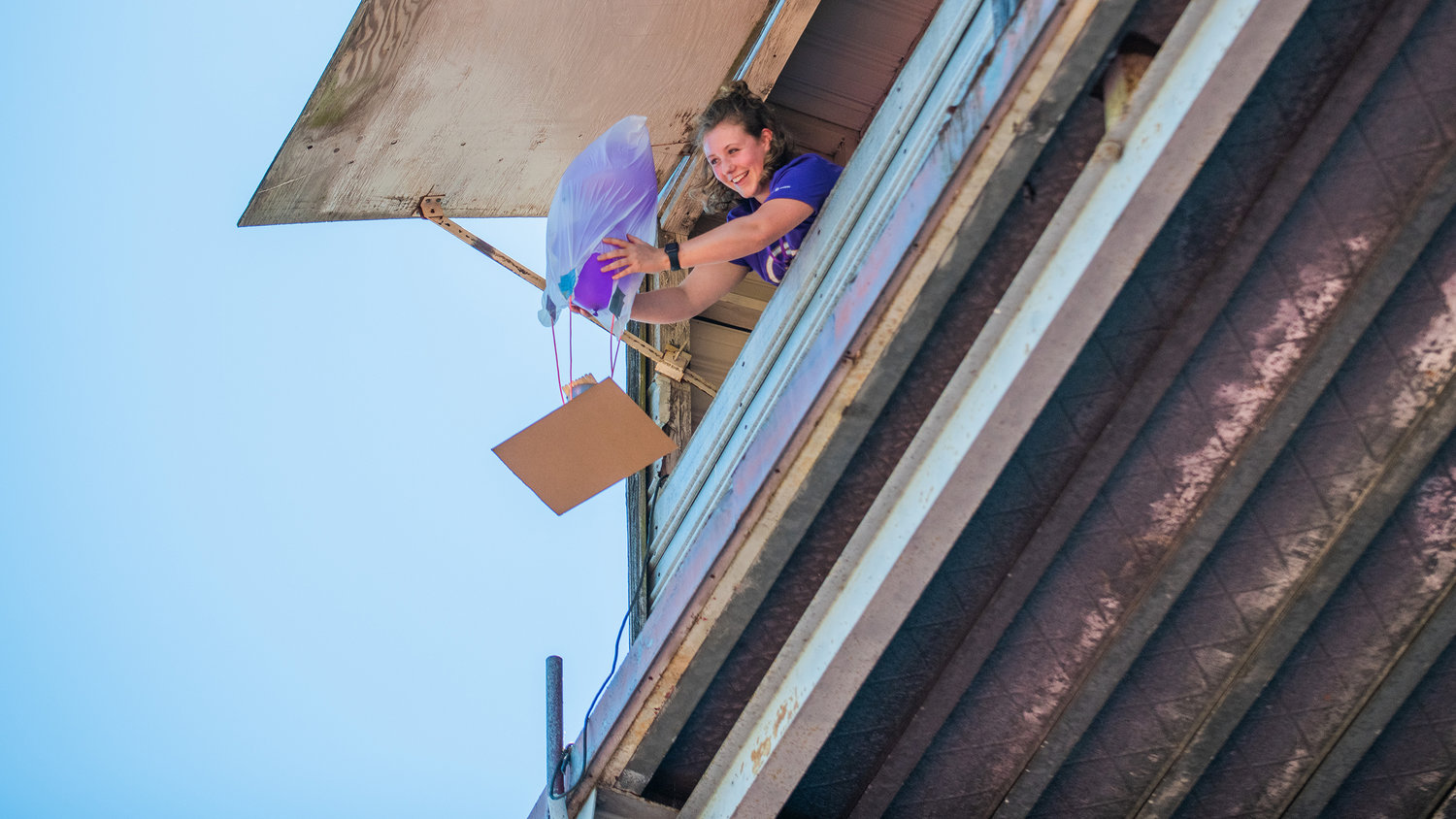 Grace O’Connor, a University of Washington staff member, smiles while dropping STEM student projects from the press box above Bearcat Stadium Tuesday in Chehalis.