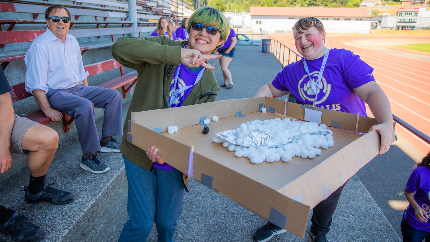 Ethan Ondong, from Napavine High School, and Sam Campagna, from W.F. West, smile for a photo with their landing pad Tuesday in Chehalis at Bearcat Stadium.