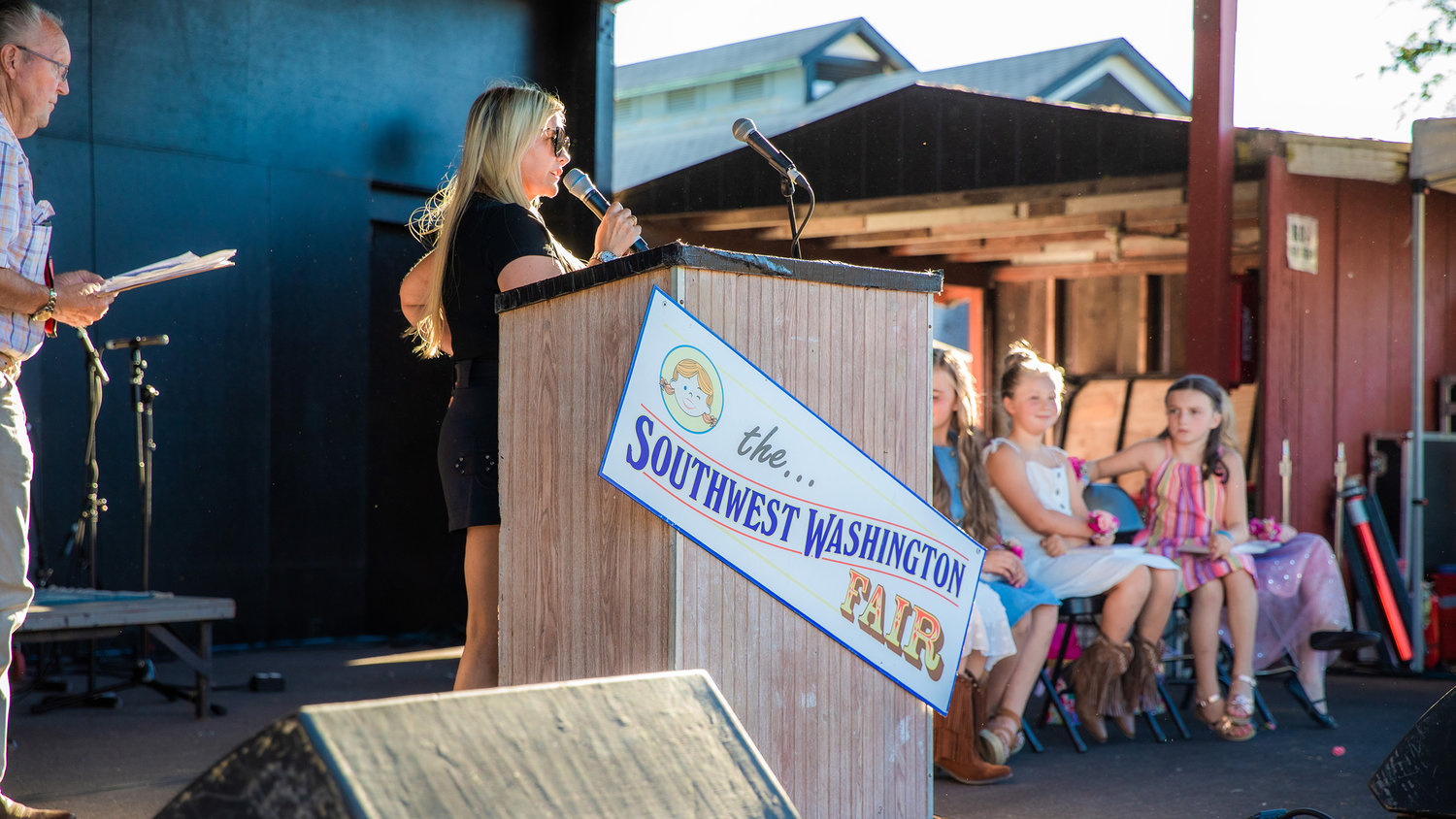 Coralee Taylor, of the Silver Agency, talks with Little Miss Friendly candidates Tuesday afternoon on the Saloon Stage at the Southwest Washington Fairgrounds.
