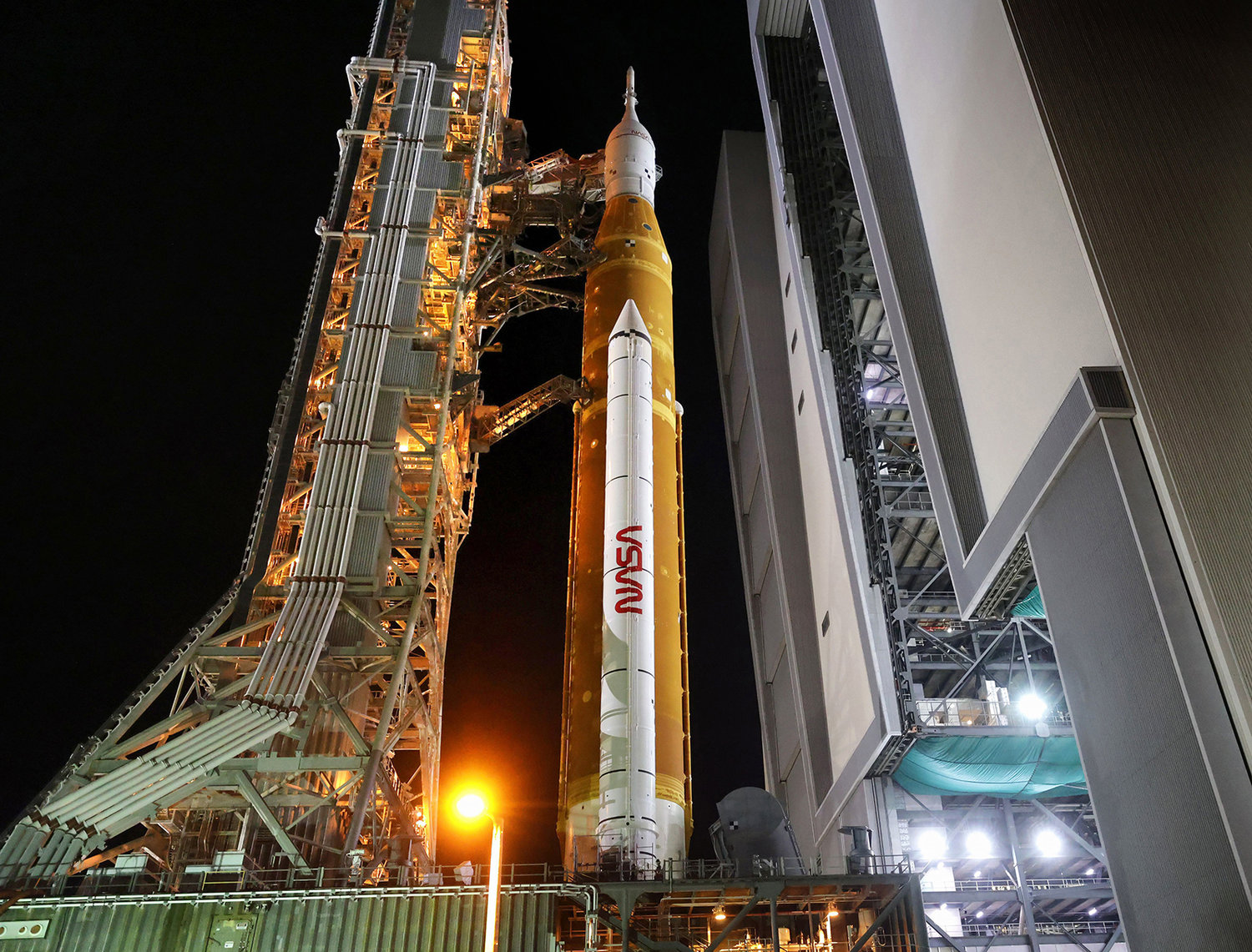 Artemis I leaves the Vehicle Assembly Building as it rolls out to launch pad 39-B at Kennedy Space Center, Florida, Tuesday, August 16, 2022. The rocket is scheduled to launch on an unmanned mission to orbit the moon on Aug. 29. (Joe Burbank/Orlando Sentinel/TNS)