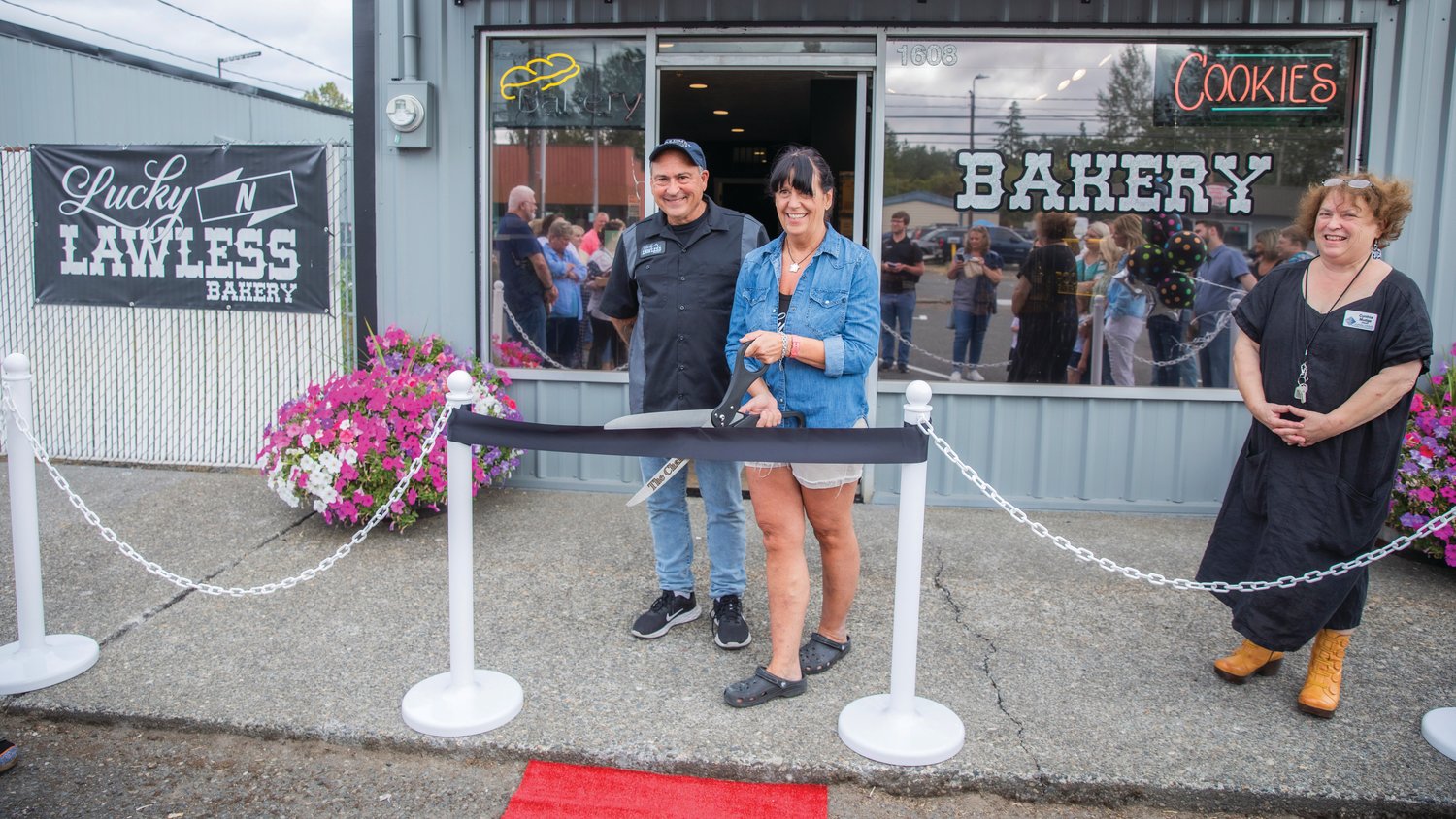 Steven and Pam Kaiser smile during a ribbon cutting ceremony for the Lucky 'N Lawless Bakery Friday afternoon in Centralia alongside Cynthia Mudge.