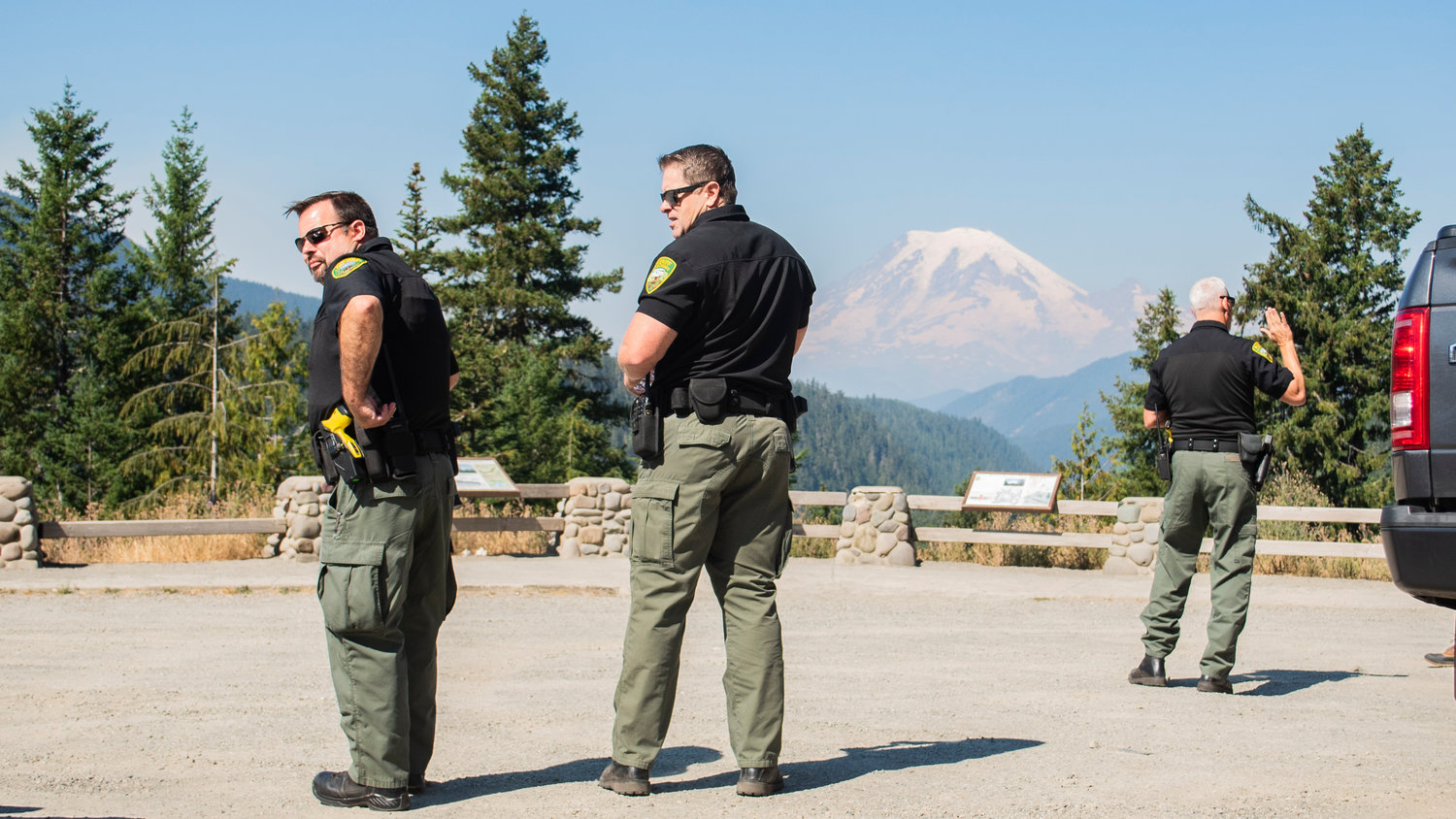 From left, Lewis County Sheriff’s Office Field Operations Chief Dusty Breen, Captain Rick Van Wyck and Sheriff Rob Snaza stand at a lookout off U.S. Highway 12 near White Pass as smoke from the Goat Rocks Fire shrouds the bottom of Mount Rainier.