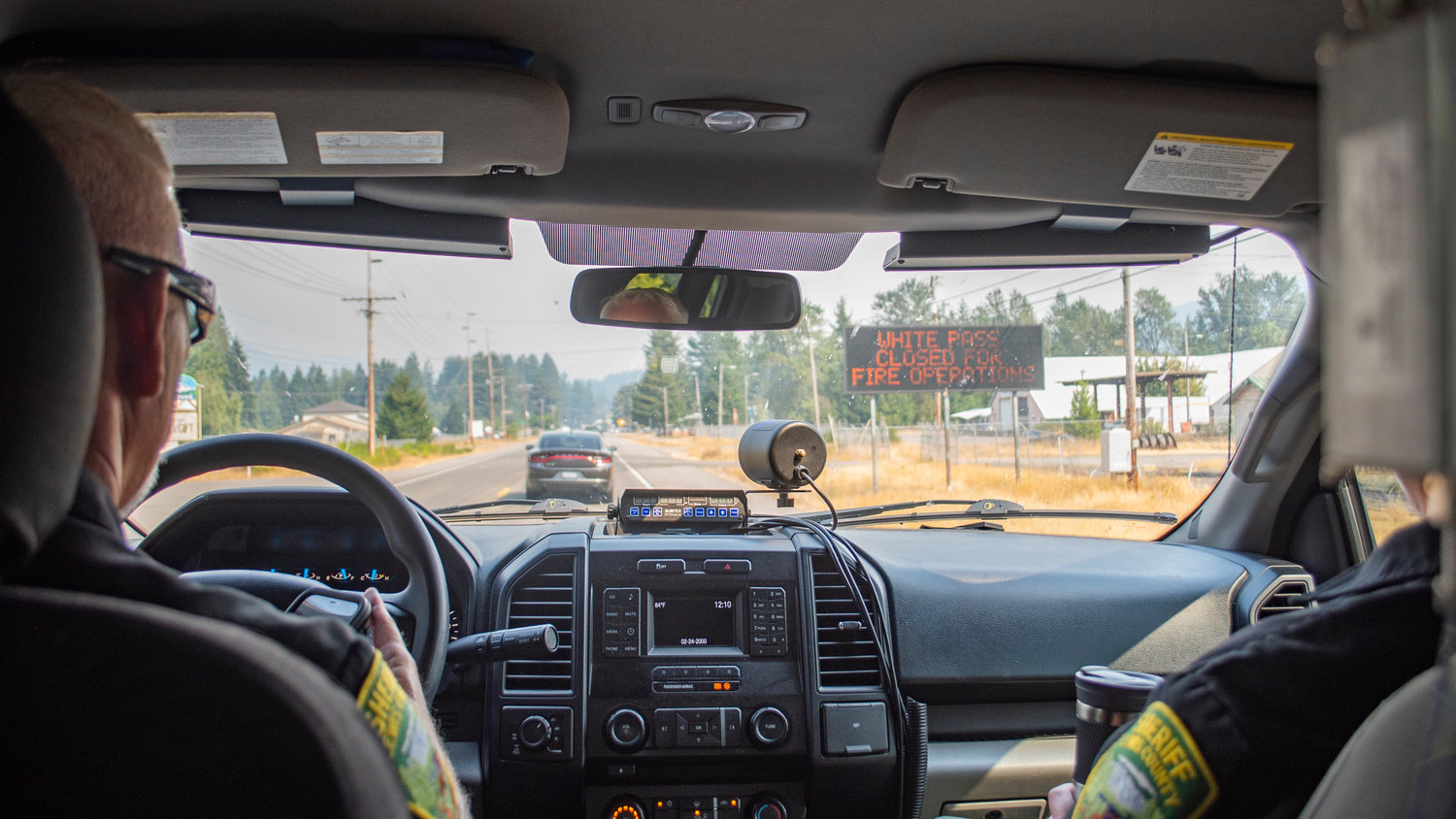 A sign warning the closure of U.S. Highway 12 is seen Saturday through the windshield of a Lewis County Sheriff’s Office patrol vehicle as Sheriff Rob Snaza and Captain Rick Van Wyck take a reporter with The Chronicle on a ridealong into the zone under evacuation orders due to the Goat Rocks Fire northeast of Packwood.