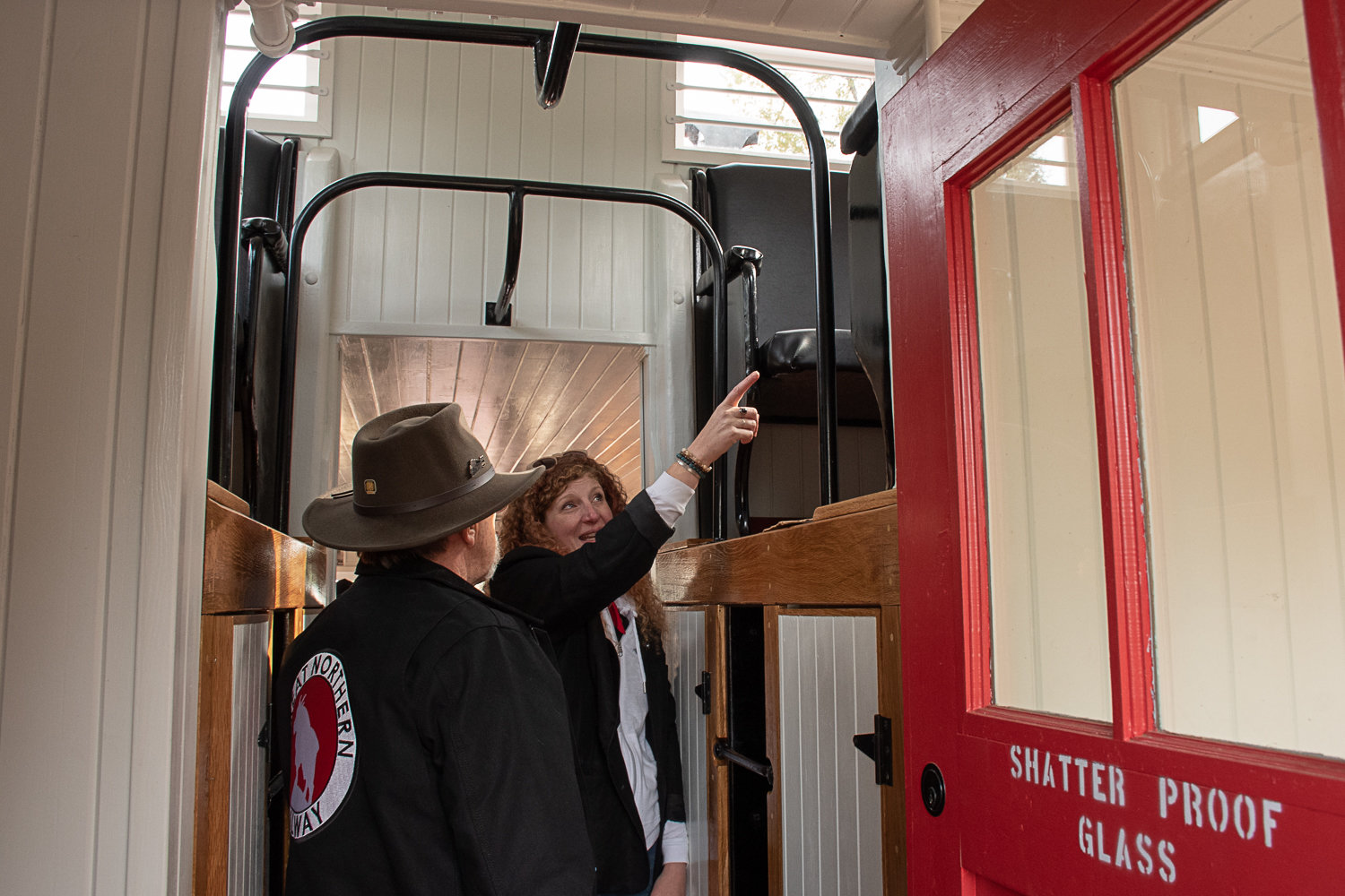 Fae Widenhoeft of SeaStar points out where she used to keep her outfits in the cupola to Don Bowman, one of the two men who restored the nearly-100-year-old caboose. Photo by Owen Sexton.