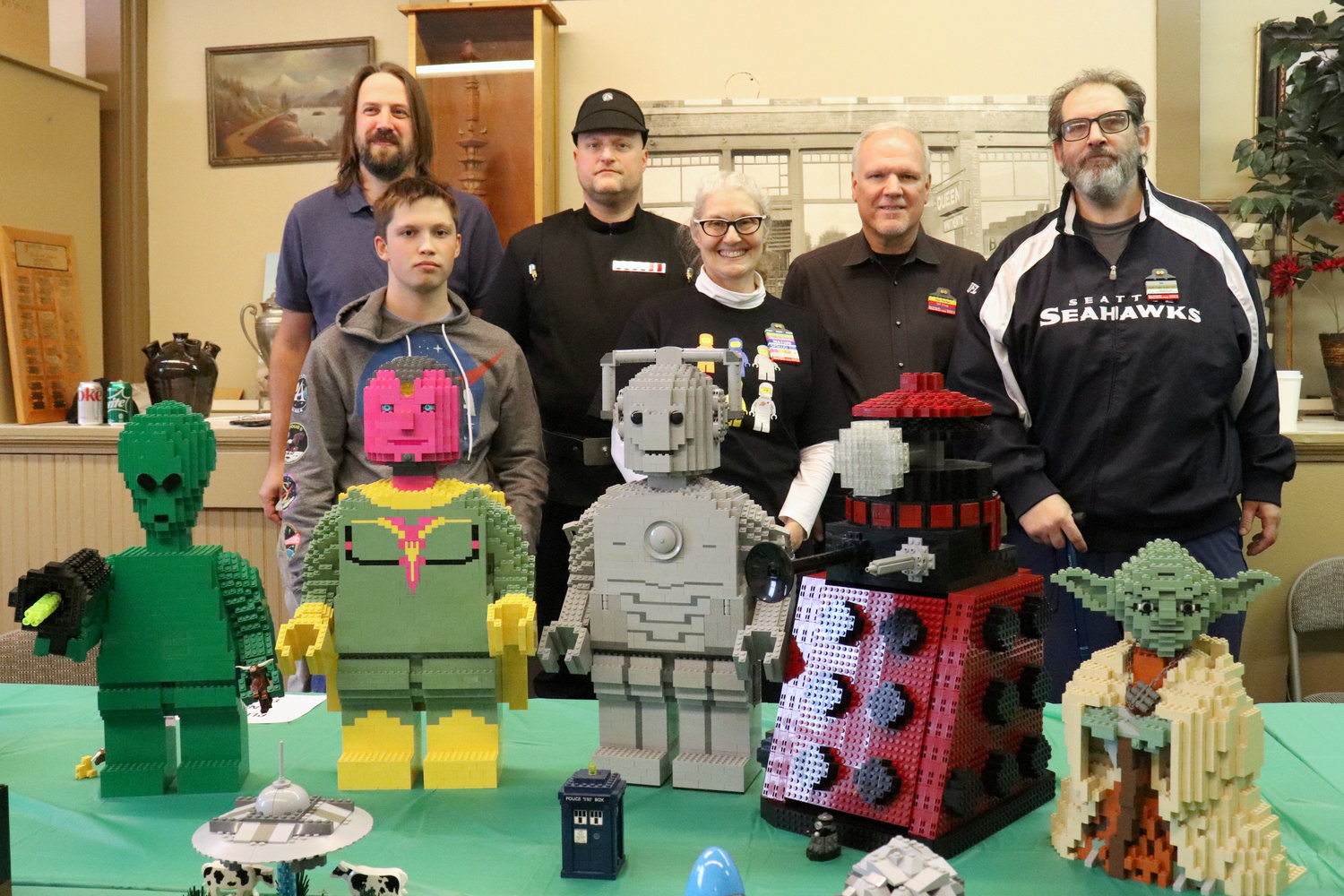 South Puget Sound Lego Users Group members, from left, Joshua Gay, Brodie James-Gay, Steve Kross, Diane Campbell, Dan Parker and Eric Law, pose behind their LEGO creations on display at the Lewis County Historical Museum during the Chehalis Flying Saucer Party on Saturday. The large figurines were built by Parker. For more information on the group, visit https://spslug.org.
