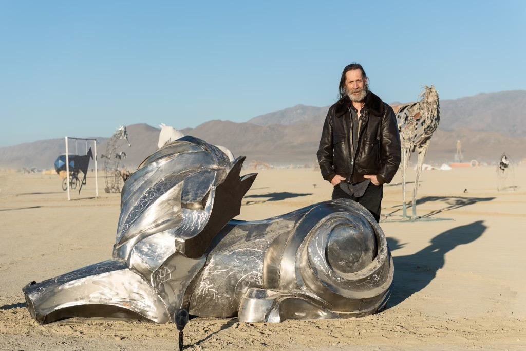 Michael Duquette and his finished horse sculpture on the playa at the Burning Man festival.