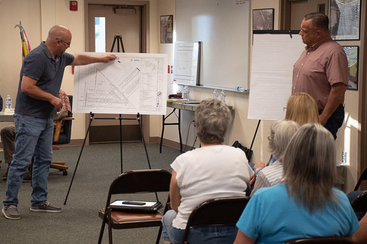 Project Engineer Bob Balmelli (left) and K & W Properties LLC Owner Karl Werner walk residents through their proposed plans for the new apartment complex.