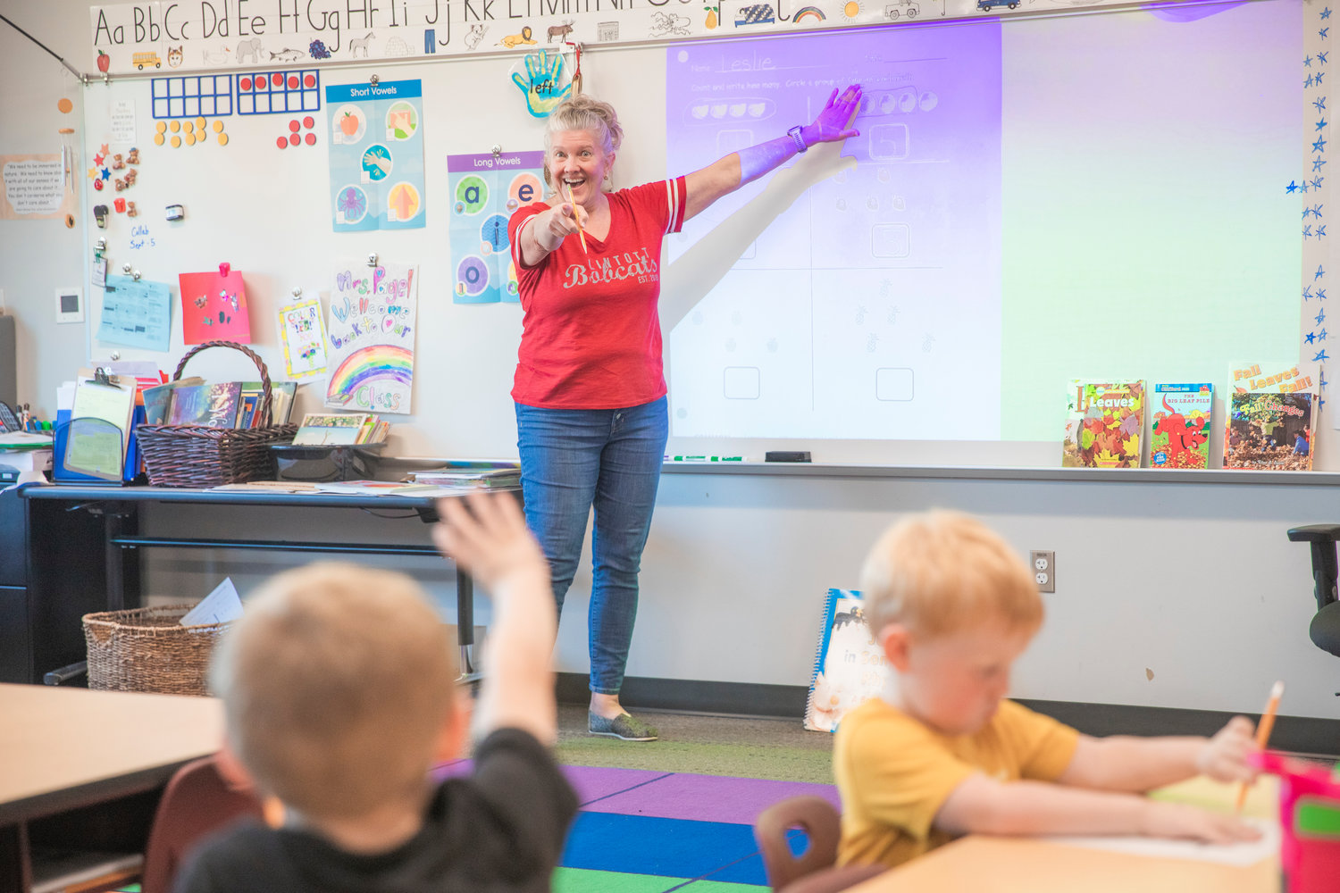 Leslie Pagel smiles as students in her first grade class use problem solving skills to answer questions on a worksheet during class on Friday at James W. Lintott Elementary in Chehalis.