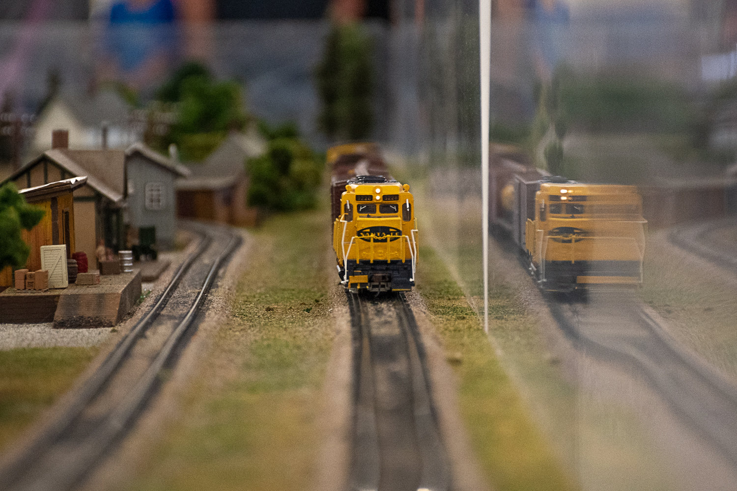 A Santa Fe locomotive pulls model freight cars down track set designed and assembled by Ted Lavremore.