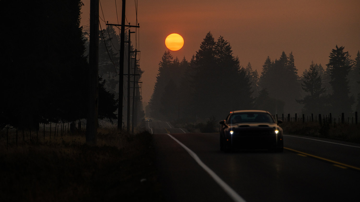 The sun sets through smoke over Old Highway 99 Southeast on Wednesday near Tenino.