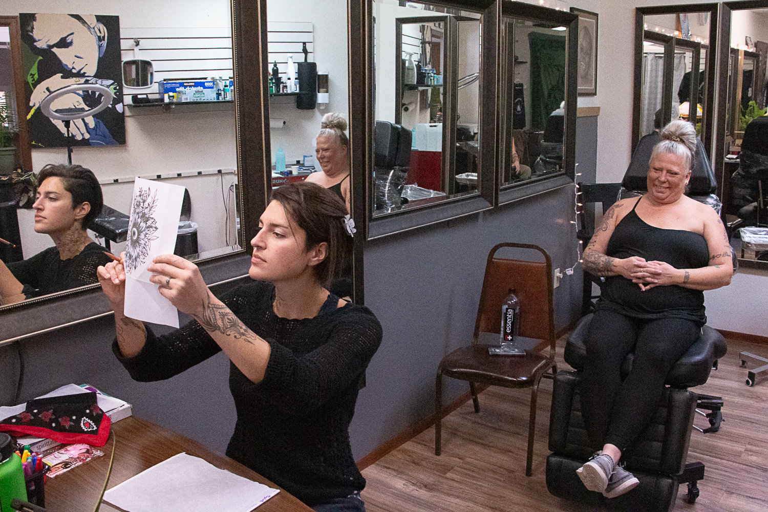 Sarah Gootgeld examines a stencil of a tattoo her client, Jen McKay, of Cispus, requested.