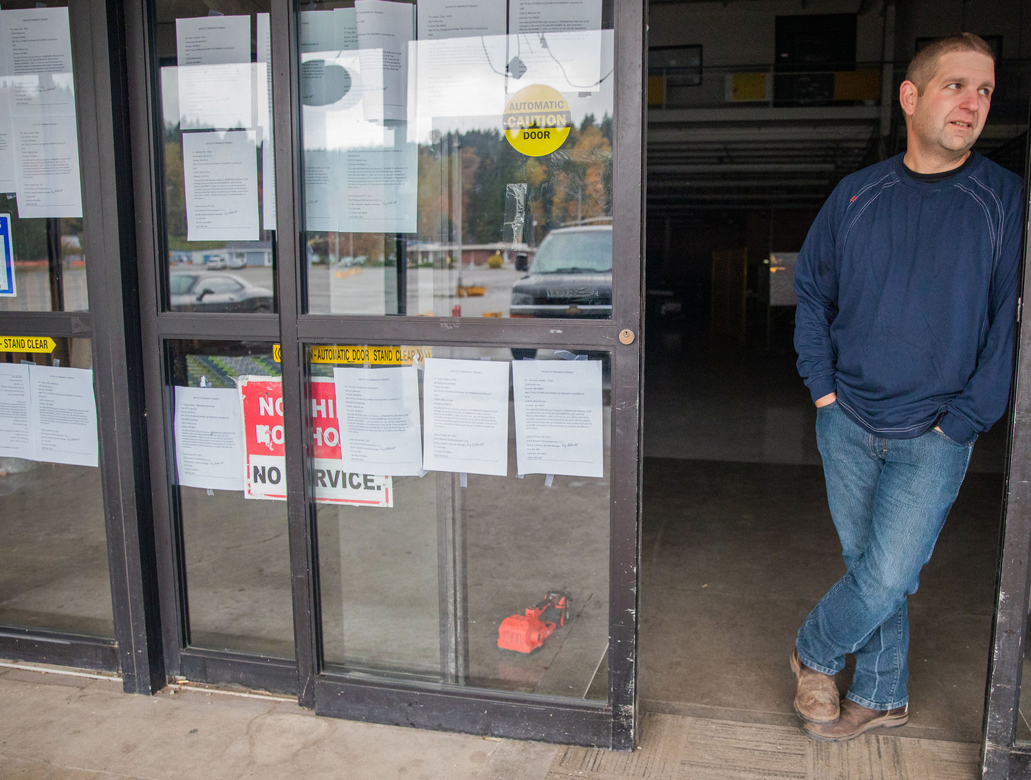 Garet Russo stands in front of multiple notices to terminate tenancy taped to an entrance of Yard Birds on Wednesday while describing the financial situation of the business.