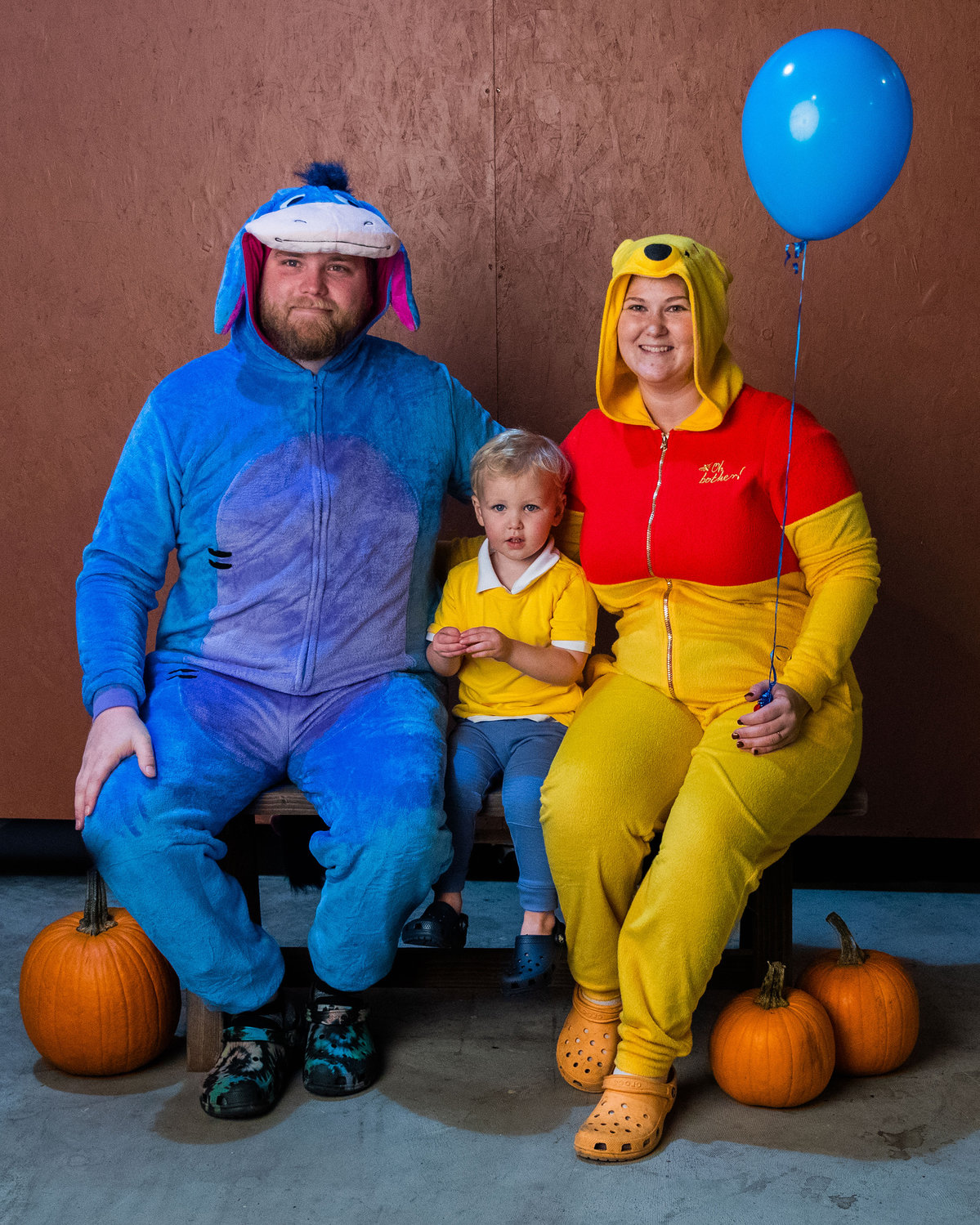 Leo Lloyd, 2, center, poses for a photo alongside Jesse and Kristi dressed as Eeyore and Winnie the Pooh during a Halloween Carnival at The White Space in downtown Centralia on Monday.