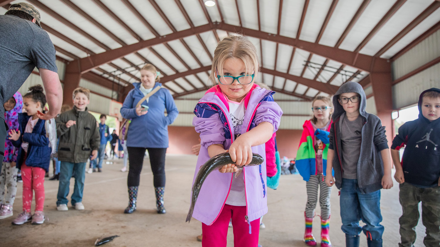 A kindergarten student in Kari Loucks’ class looks to the camera while holding up a trout at Morton Elementary on Monday.