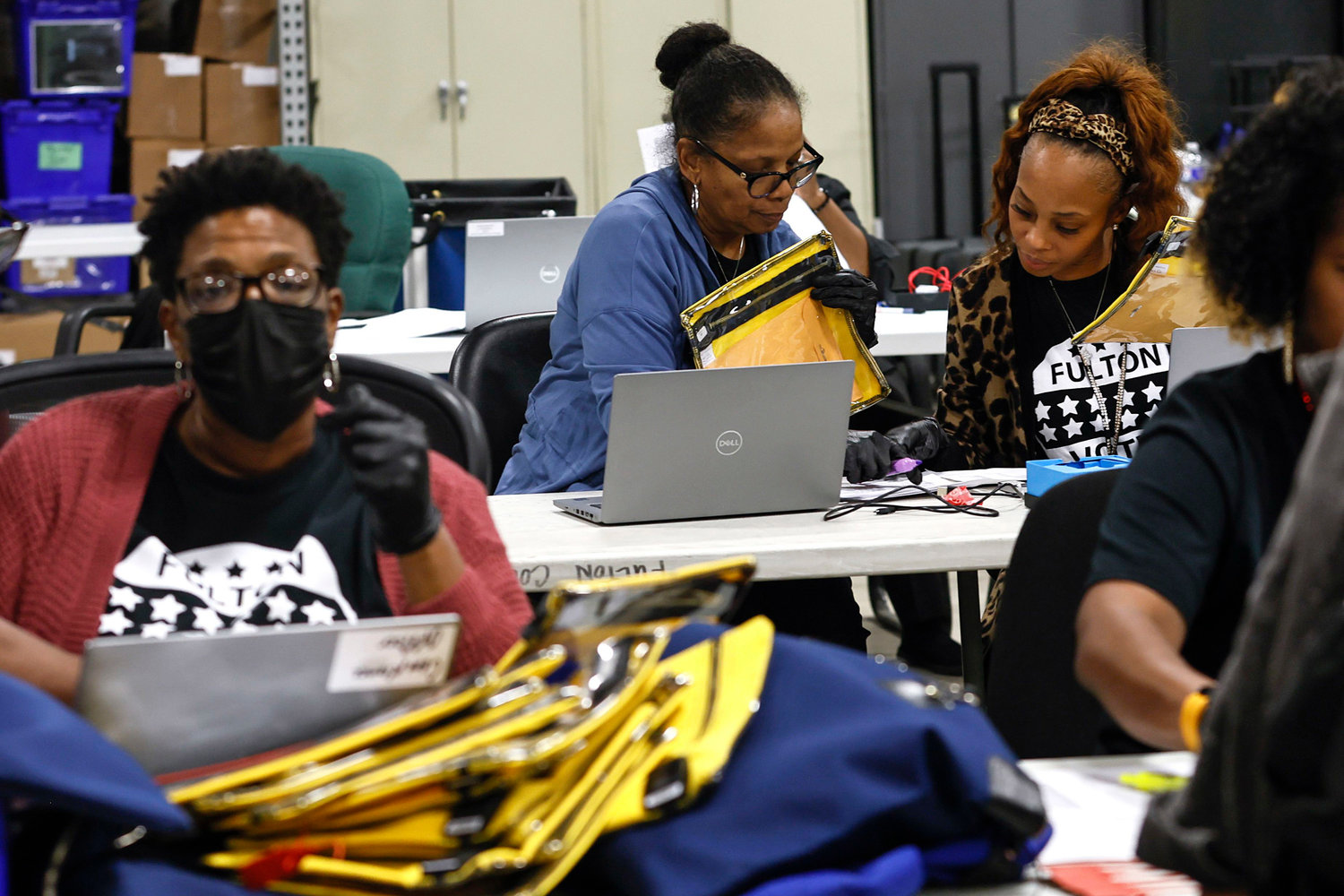 Poll workers prepare to open pouches containing voter memory cards from various precincts at The Fulton County Elections Warehouse on Tuesday, Nov. 8, 2022. (Natrice Miller/The Atlanta Journal-Constitution/TNS)