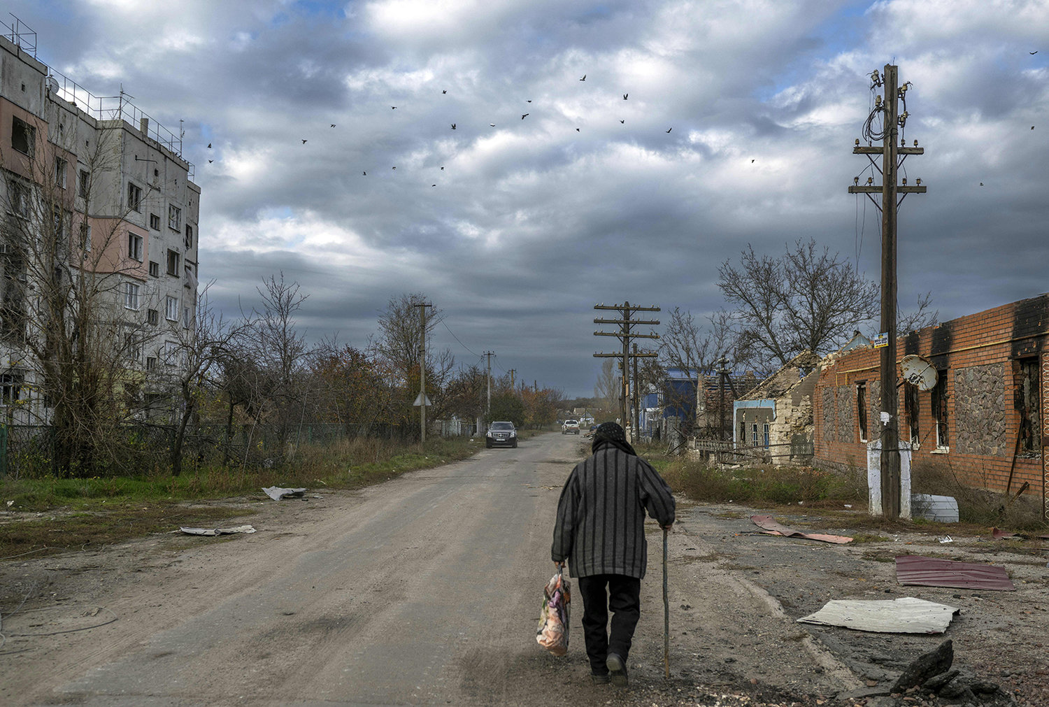 An old woman walks in the Kherson region village of Arkhanhelske on Nov. 3, 2022, which was formerly occupied by Russian forces. (Bulent Kilic/AFP via Getty Images/TNS)