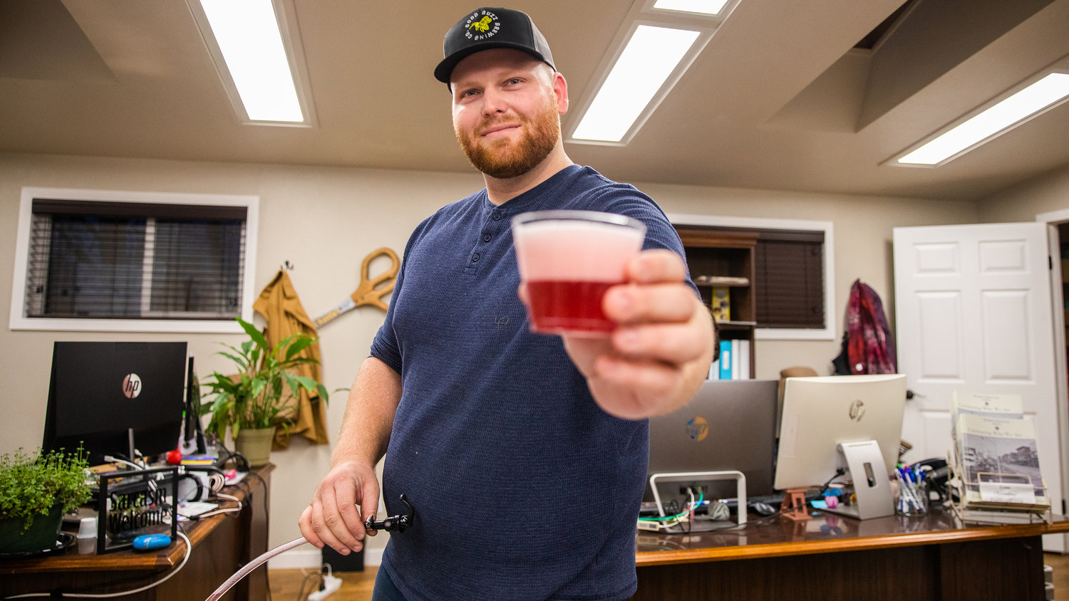 Forrest Chesvick, owner of Good Buzz Brewing Company, smiles and serves up drinks during a Business After Hours event at the Centralia-Chehalis Chamber of Commerce building.