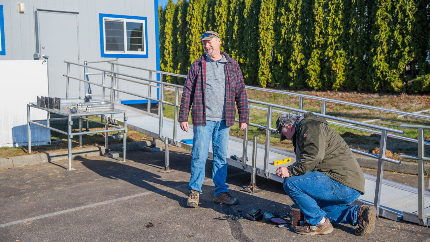 Twin Cities Rotarians Michael Ervin and Greg Mitchell work on an aluminum ramp Saturday afternoon for a portable building outside the Veterans Memorial Museum in Chehalis.