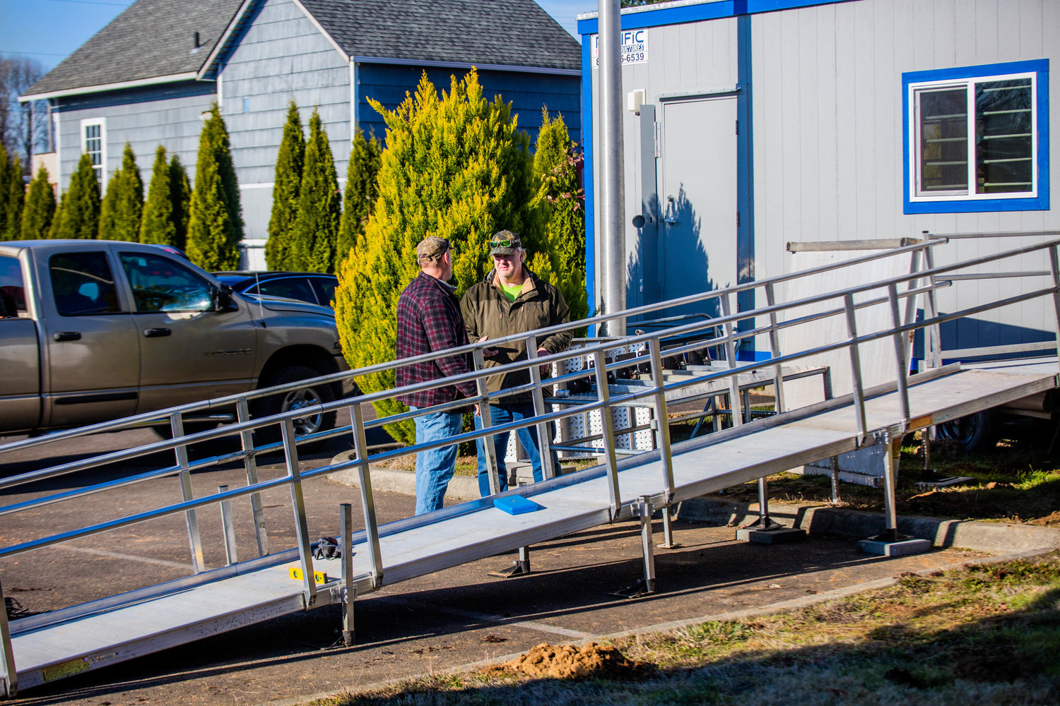 Twin Cities Rotarians Michael Ervin and Greg Mitchell work on an aluminum ramp Saturday afternoon for a portable building outside the Veterans Memorial Museum in Chehalis.