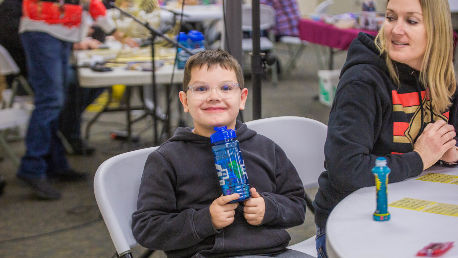 Banks Thomas, 7, smiles for a photo with a water bottle full of candy he won during Twin Cities Rotary Club Turkey Bingo in the Chehalis Eagles building on Saturday afternoon.