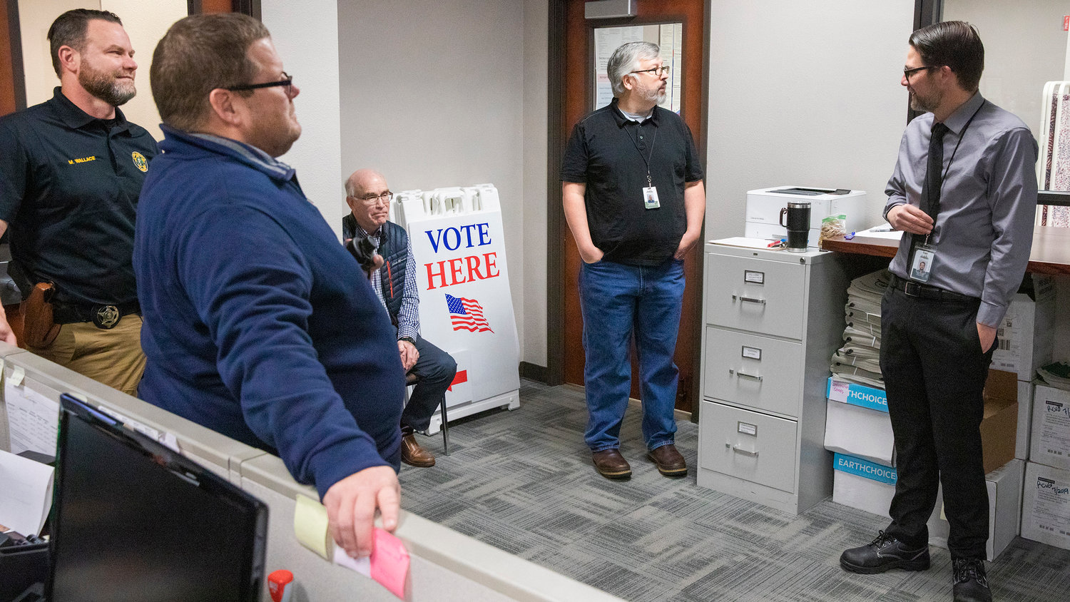 A member of the Lewis County Sheriff’s Office stands guard as Prosecutor Jonathan Meyer, Auditor Larry Grove, Chief Deputy Auditor Tom Stanton and Elections Supervisor Terry Jouper attend a canvasing board meeting Wednesday morning at the Lewis County Courthouse.