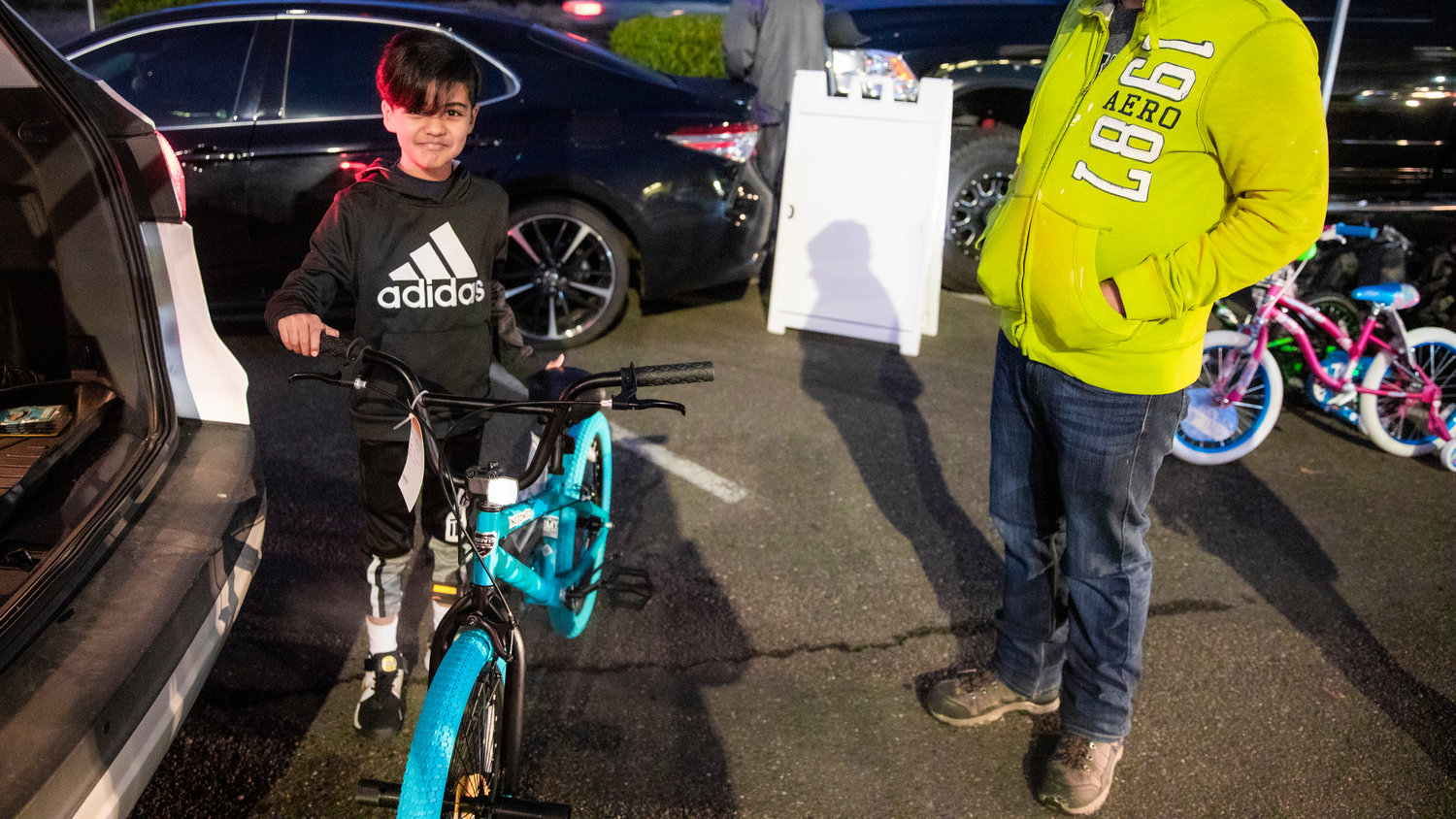 Emilio, 8, poses for a photo with his new bike during a “Choose Local Black Friday” giveaway hosted by the Centralia-Chehalis Chamber of Commerce Wednesday evening in the Lewis County Mall parking lot.