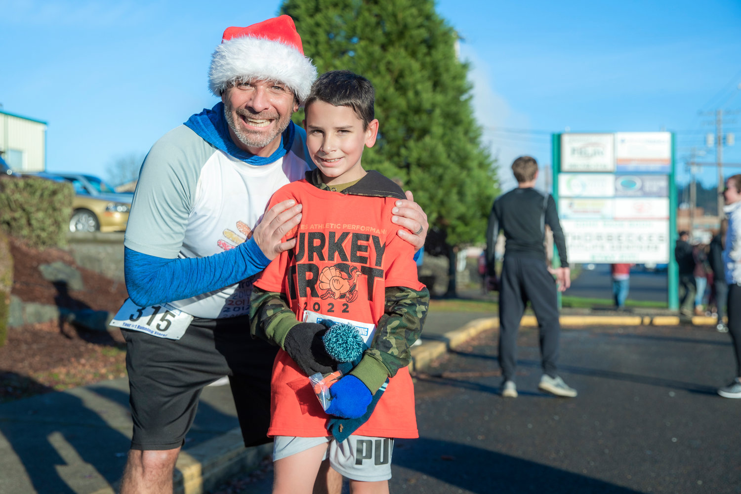 State Rep. Peter Abbarno smiles for a photo with his son Antonio after he was the first 12 and under runner to complete the Turkey Trot 5K Thanksgiving morning outside Thorbeckes in Chehalis.