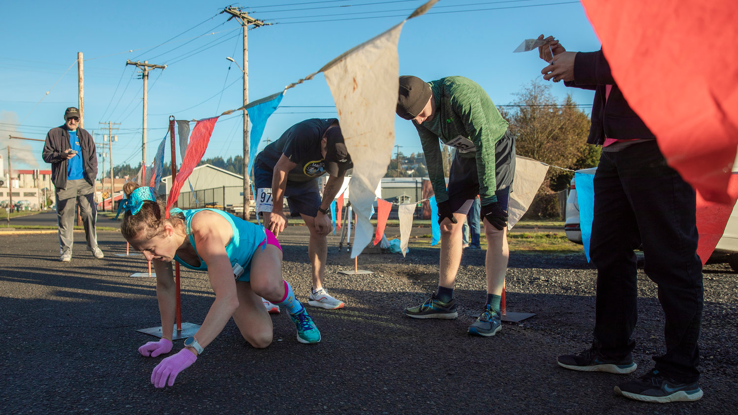 Linsie Fisher, of Raymond, John Lopez, of Chehalis, and Gunnar Morgan, of Rochester, attempt to regain their breath after being the first three to complete the Turkey Trot 5K Thanksgiving morning outside Thorbeckes in Chehalis.