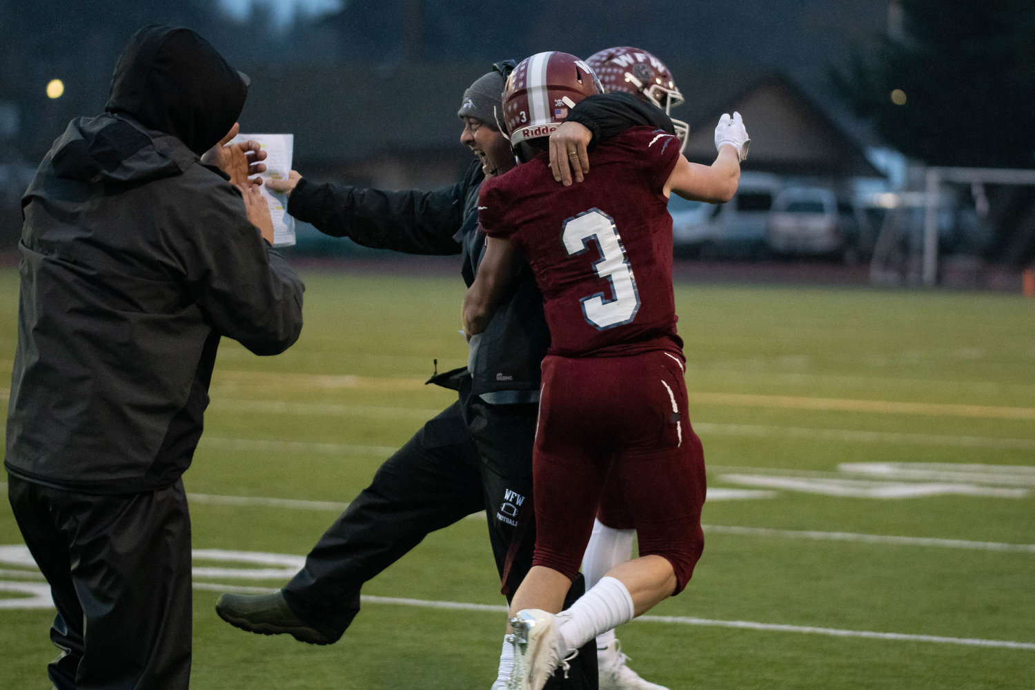 W.F. West's Ross Kelley (3) celebrates with his coach Dan Hill against North Kitsap in the 2A state semifinals Nov. 26 at Tumwater District Stadium.